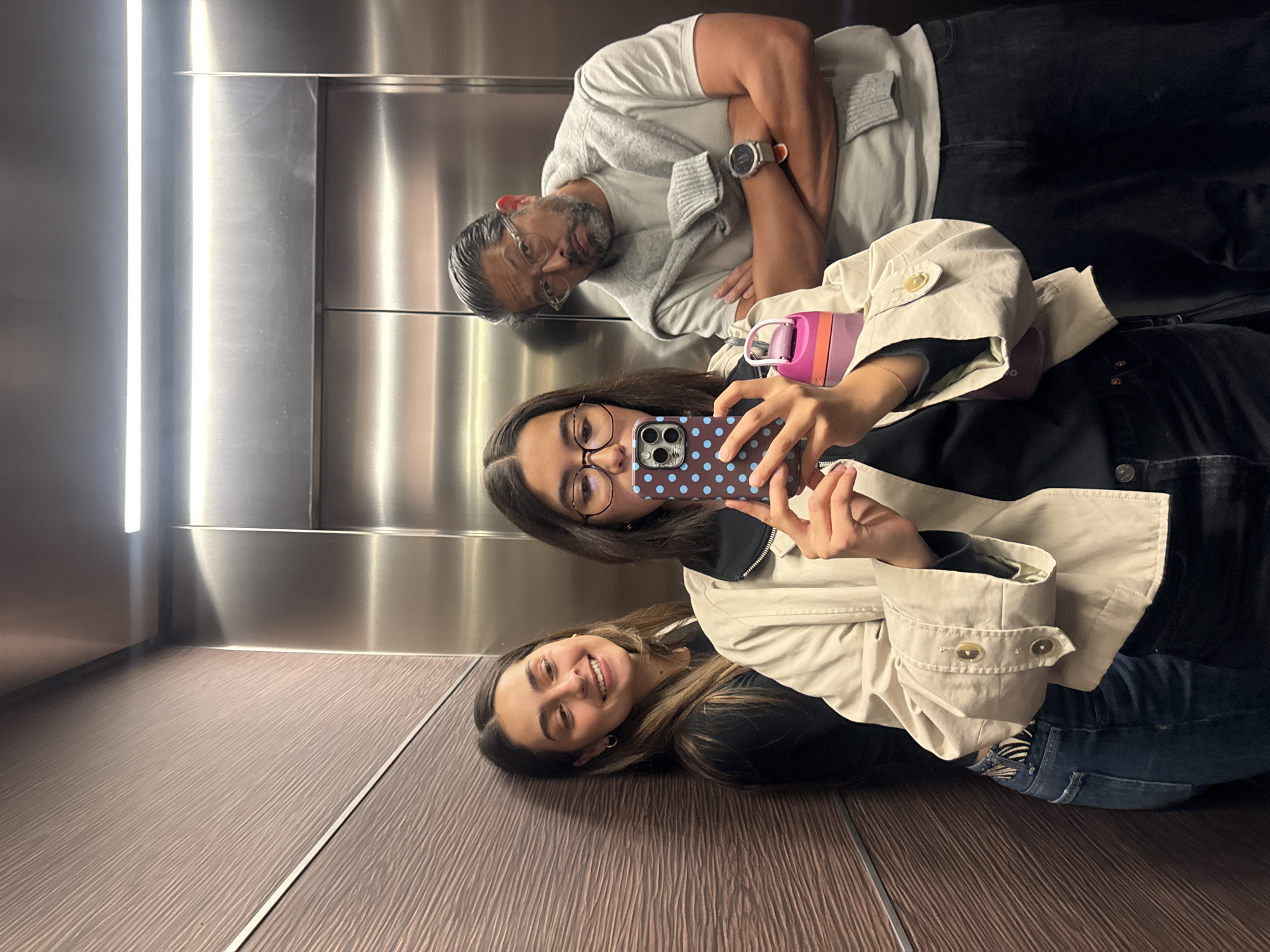 Woman lies on elevator floor in playful moment