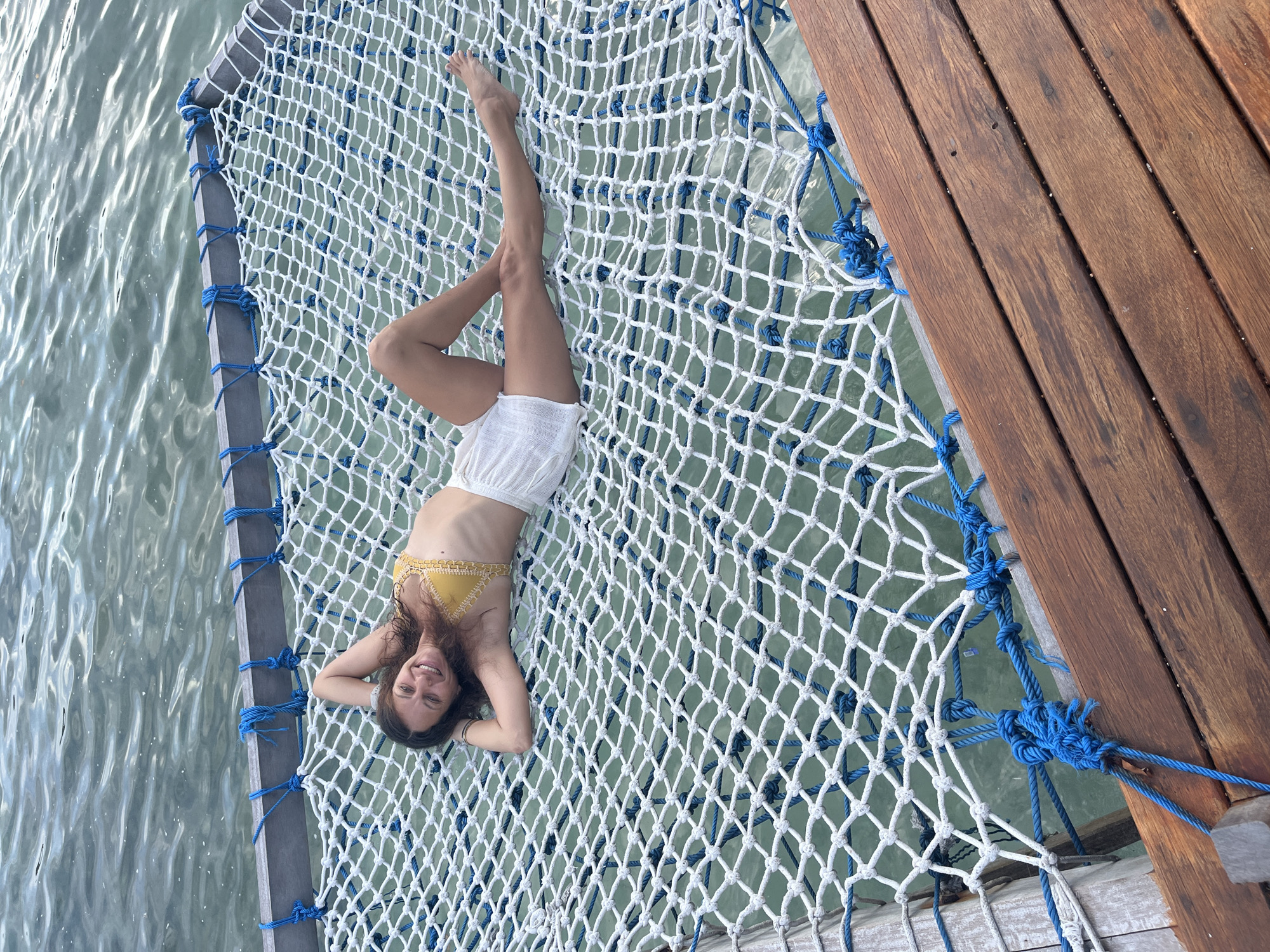 Relaxing on a net hammock over turquoise water in Nusa Penida