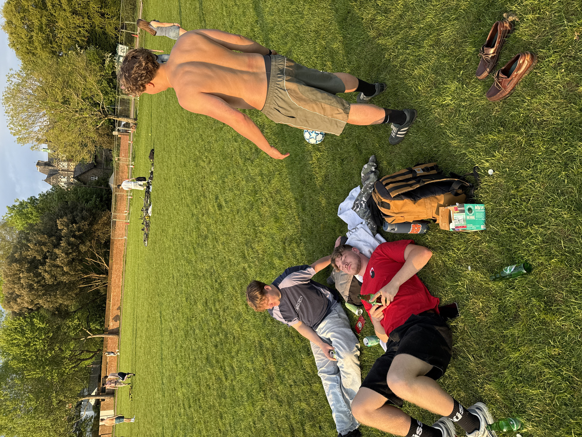 Young men enjoy sunny afternoon soccer gathering in Cardiff park
