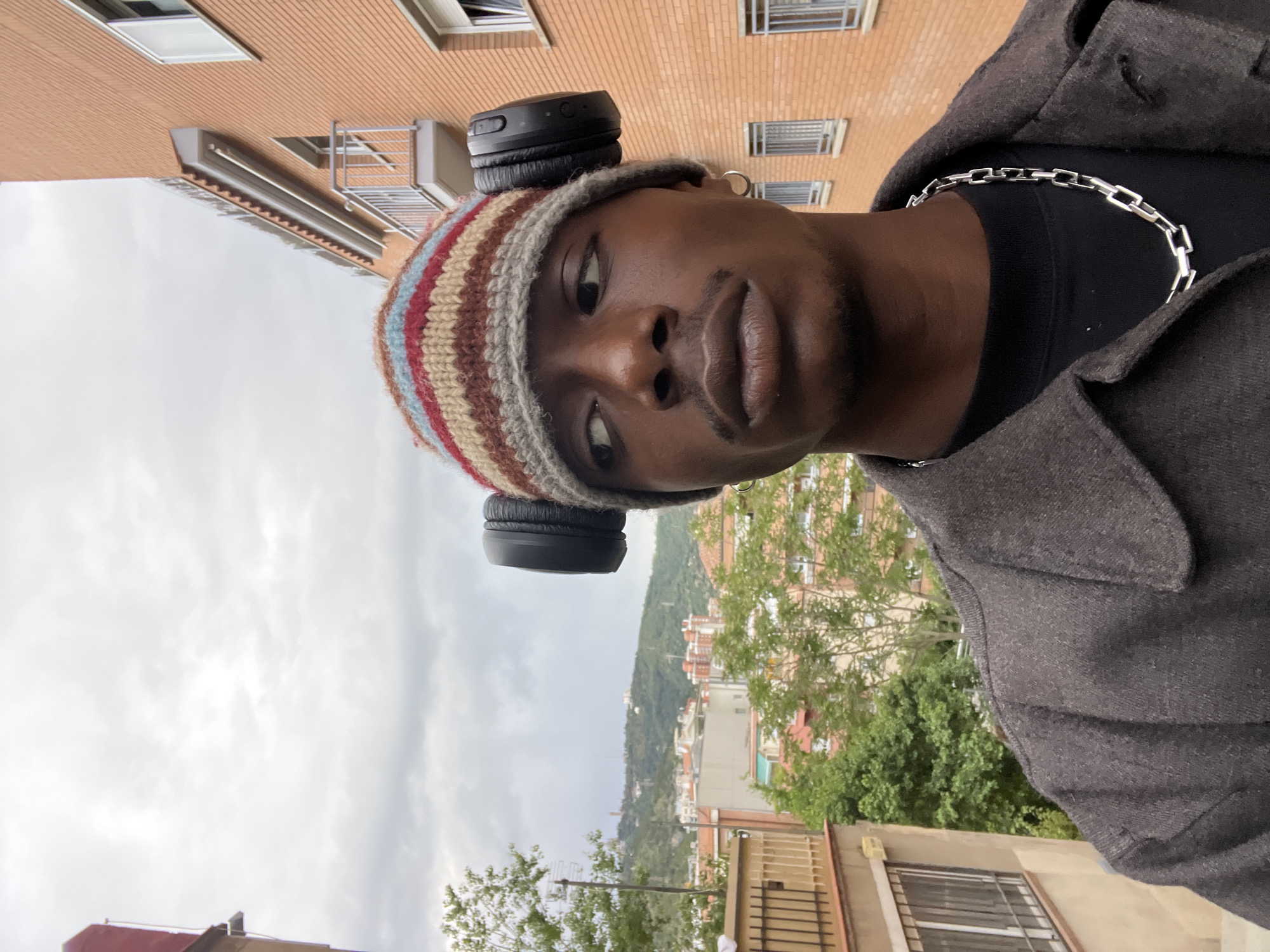 Man in striped beanie photographed multiple times on Barcelona street