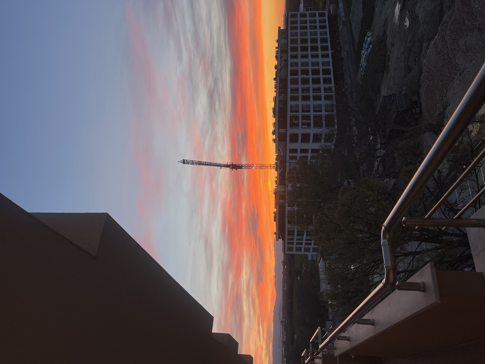 Construction crane silhouetted against colorful sunset in Plovdiv, Bulgaria