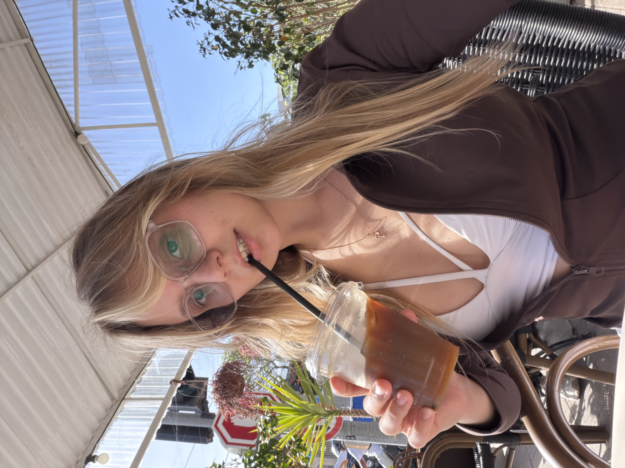 Woman enjoys drink at outdoor cafe in Bat Yam