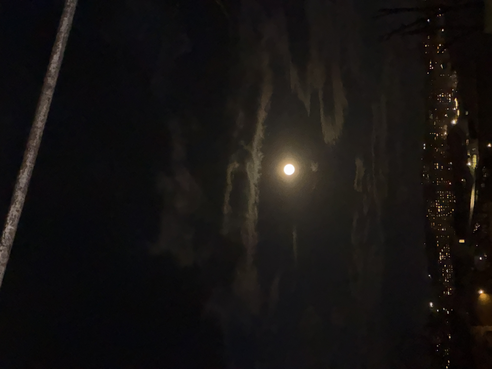 Full moon photographed through clouds in Yerevan night sky