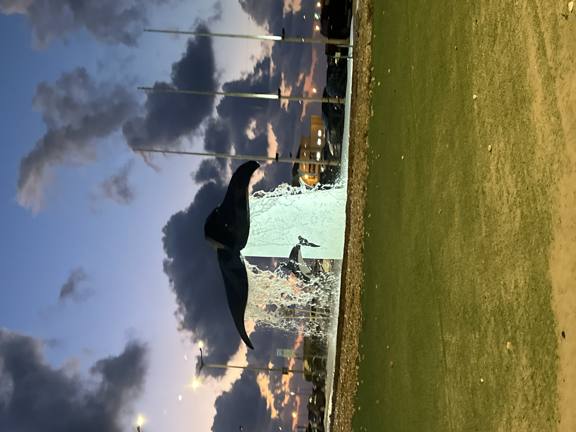 Kiryat Yam waterfront at dusk: sculptures, dining, and lit archways