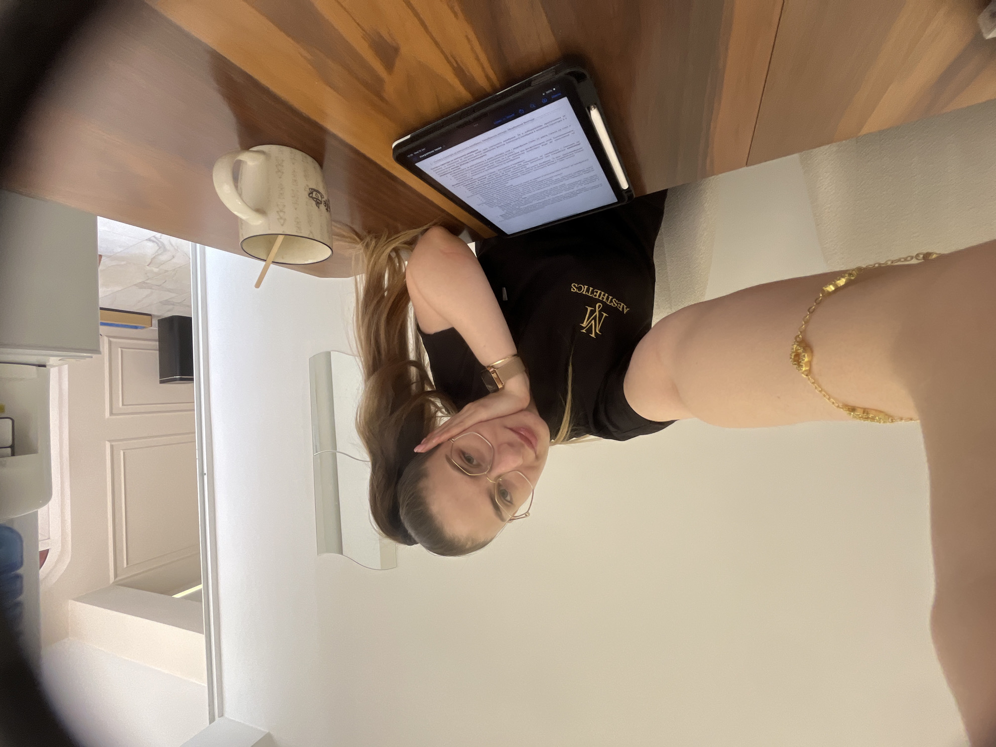 Woman in scrub top takes selfies while working at desk
