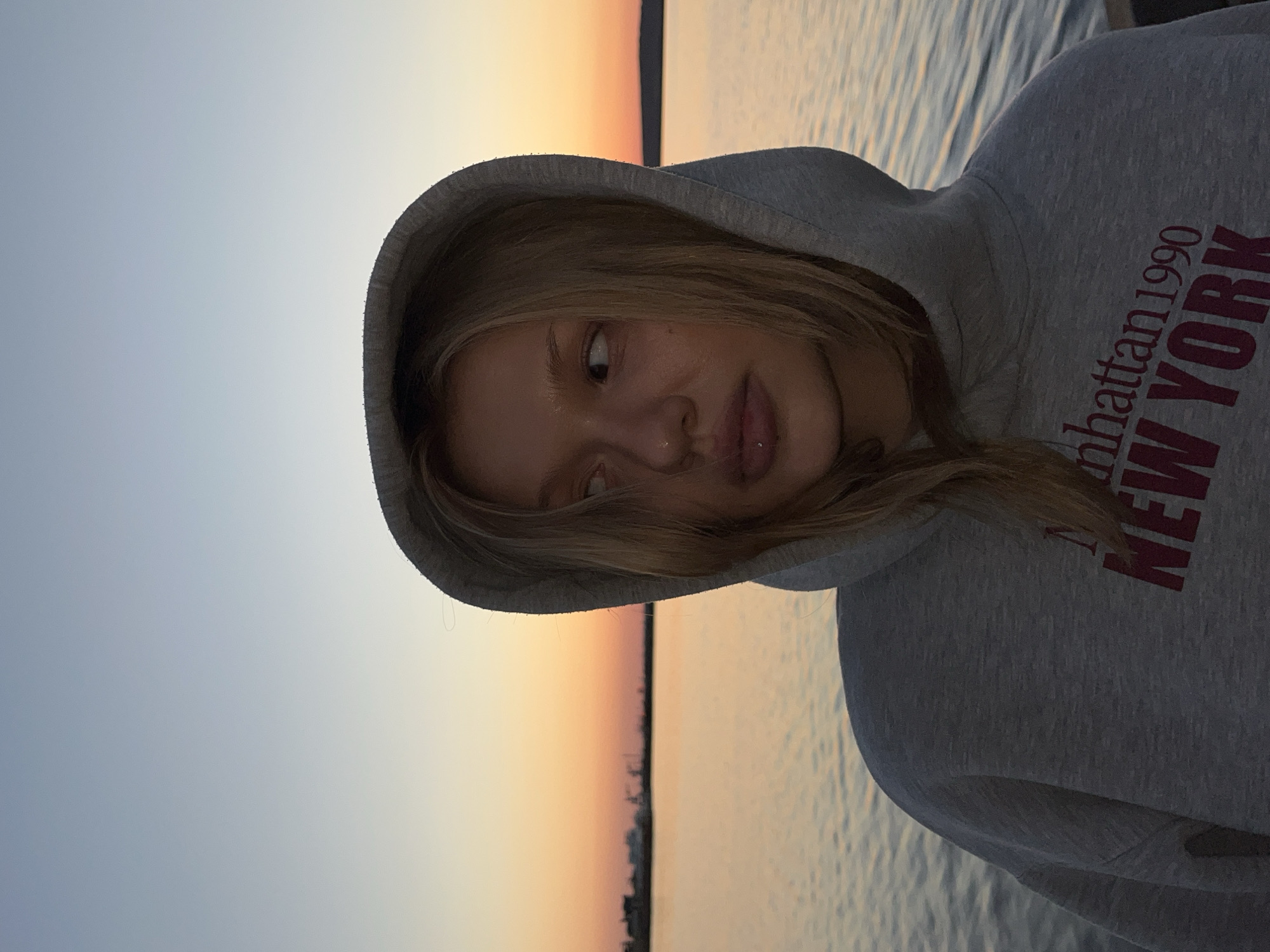 Two women photograph sunset poses by water in Chaikovsky