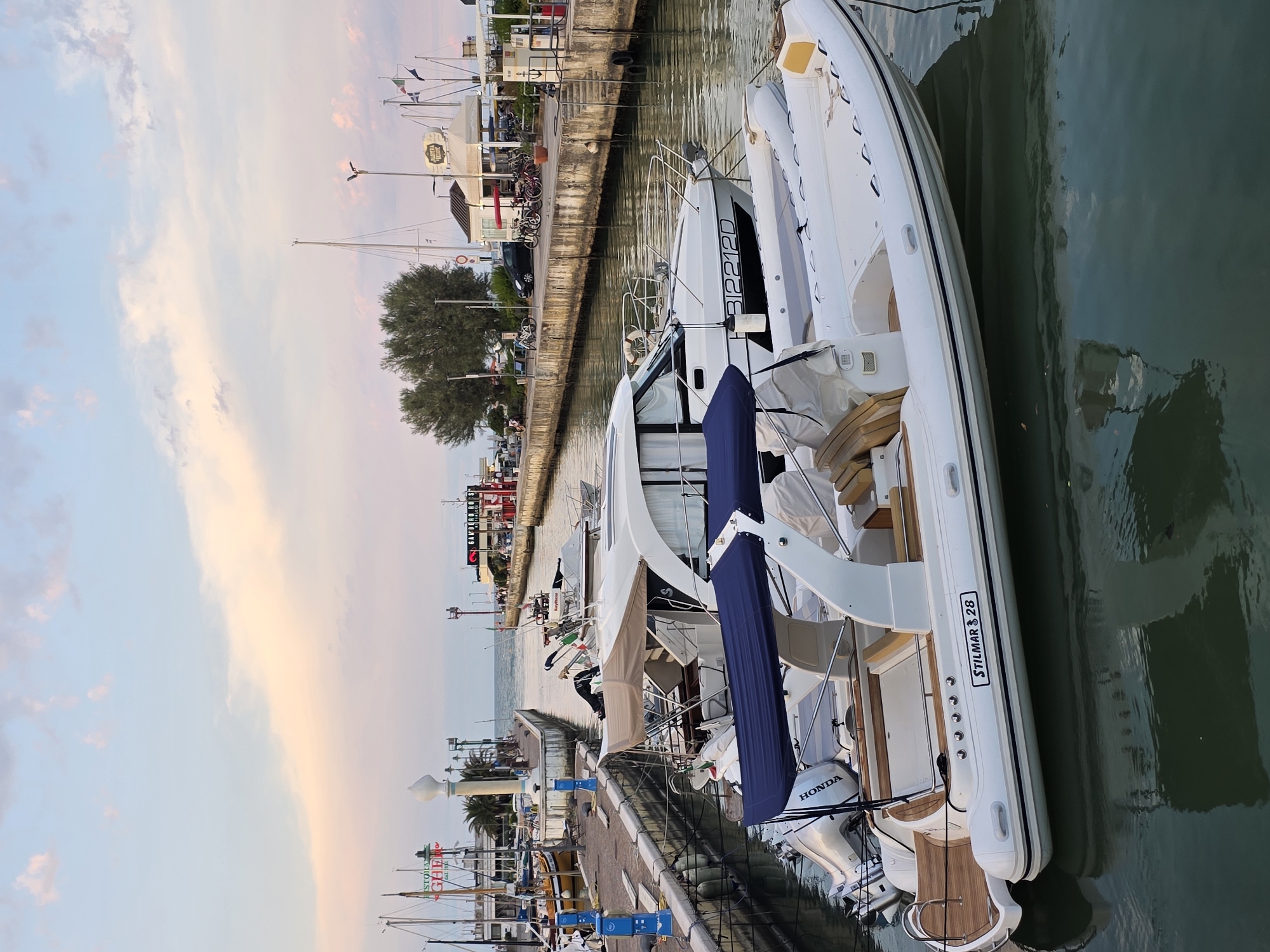 Boats docked at sunset along Riccione's harbor promenade