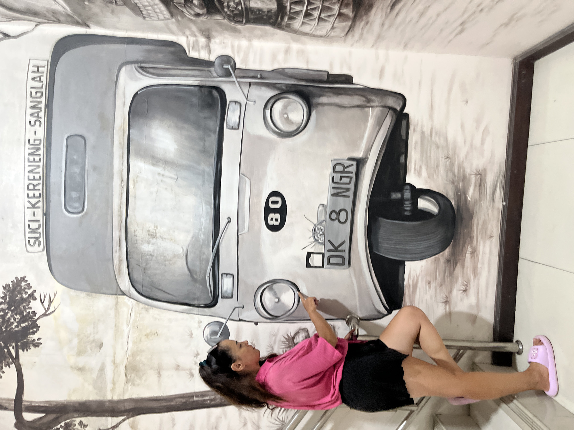 Posing across a stretch of black and white murals in Kuta Selatan