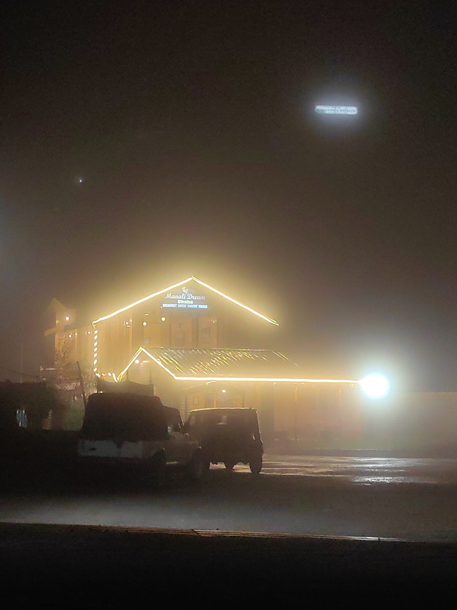 Foggy night in Kulang, white car cutting through the mist