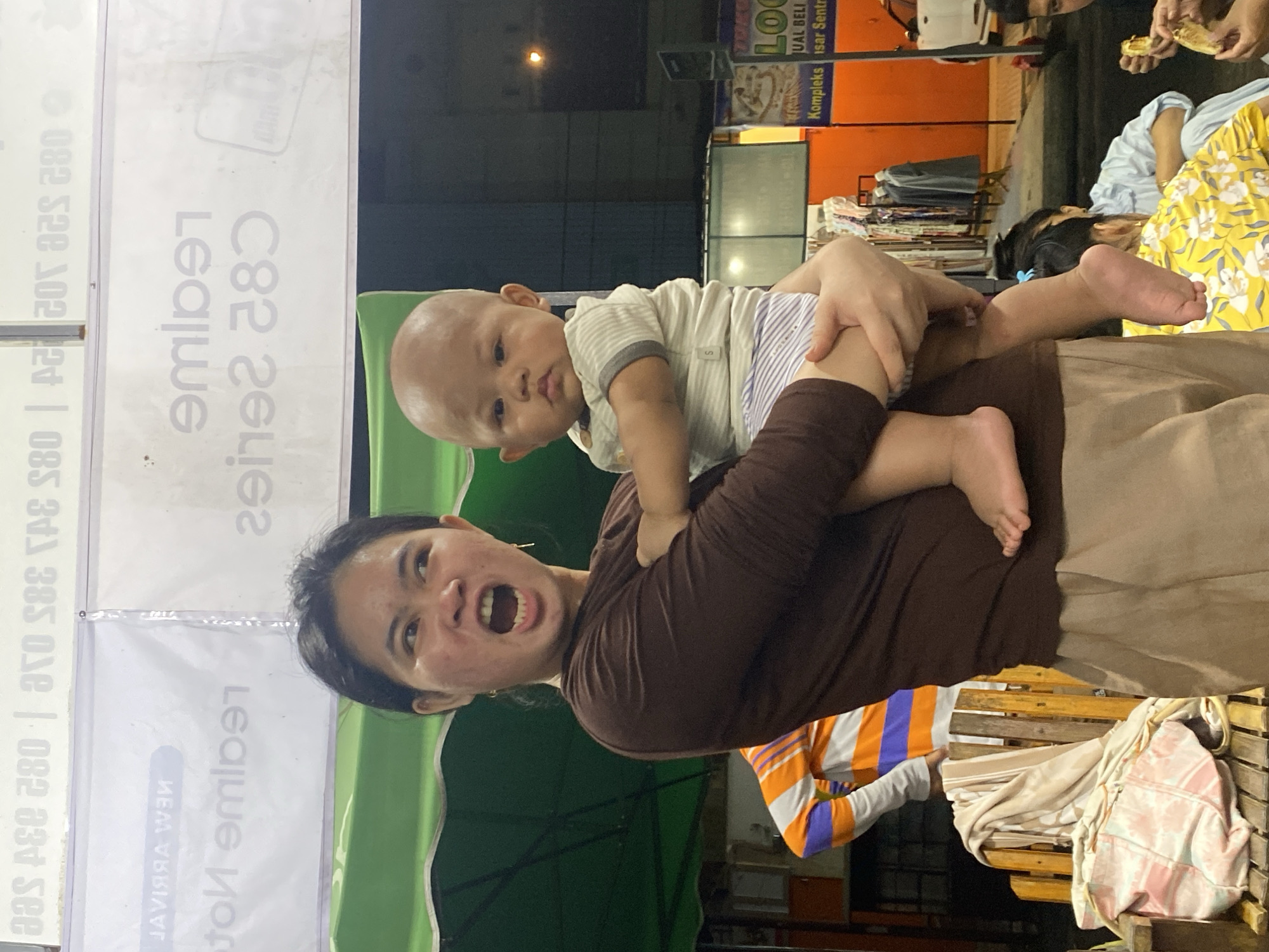 Evening family hangout outside shops in Ta', Indonesia
