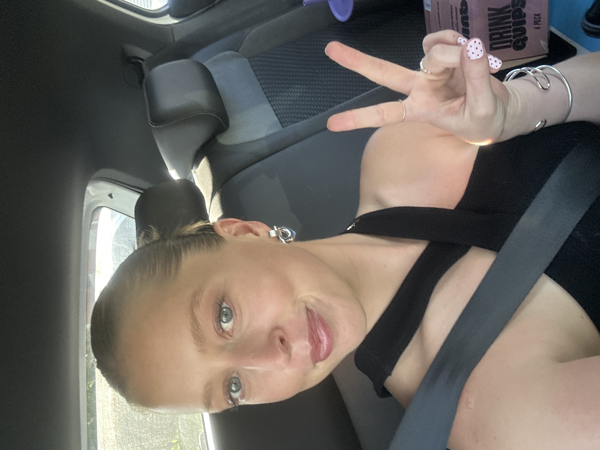 Woman makes peace sign gesture in car in Thirroul