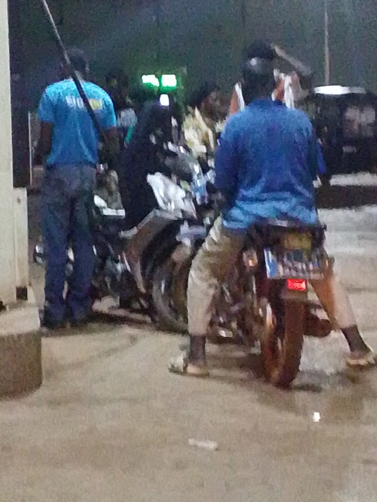 Nighttime street gathering with motorcycles and vehicle in Tamale