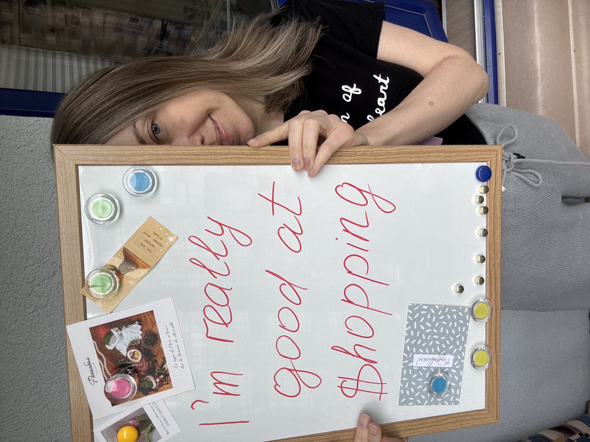 Woman writes shopping message on whiteboard in Kudrovo home