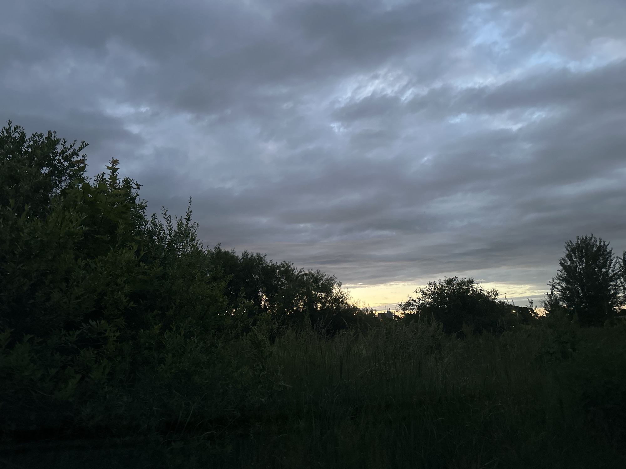 Storm clouds gather over Tallinn at dusk, chimney in frame