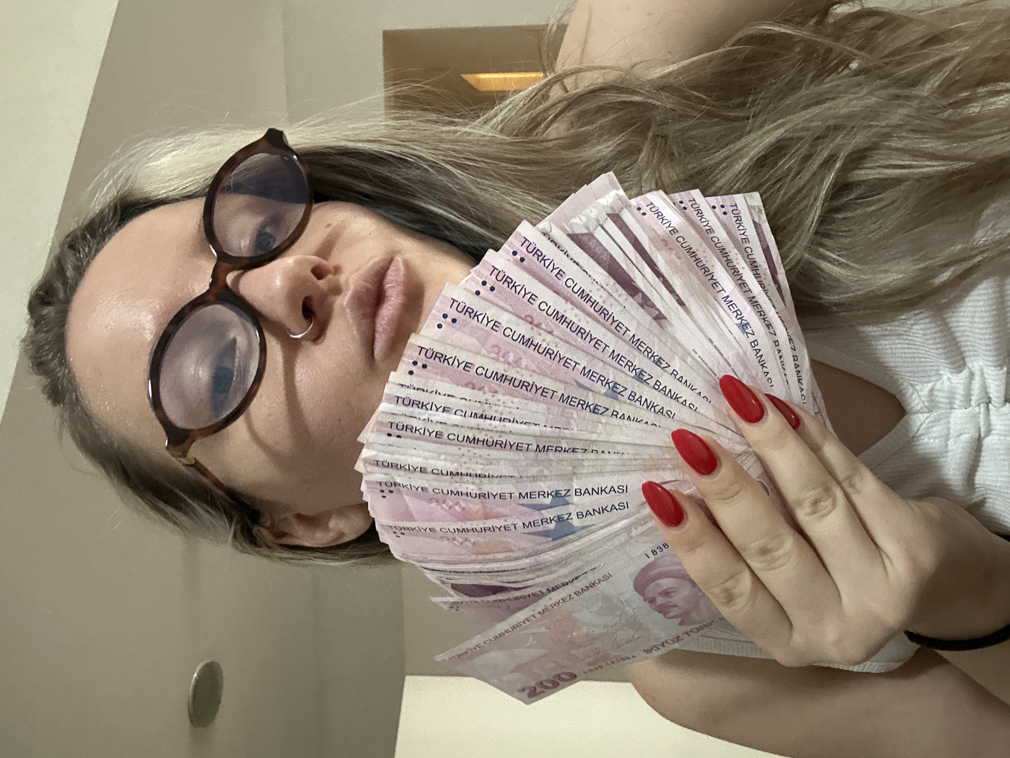 Woman displays Turkish Lira banknotes alongside personal collections in Esenyurt