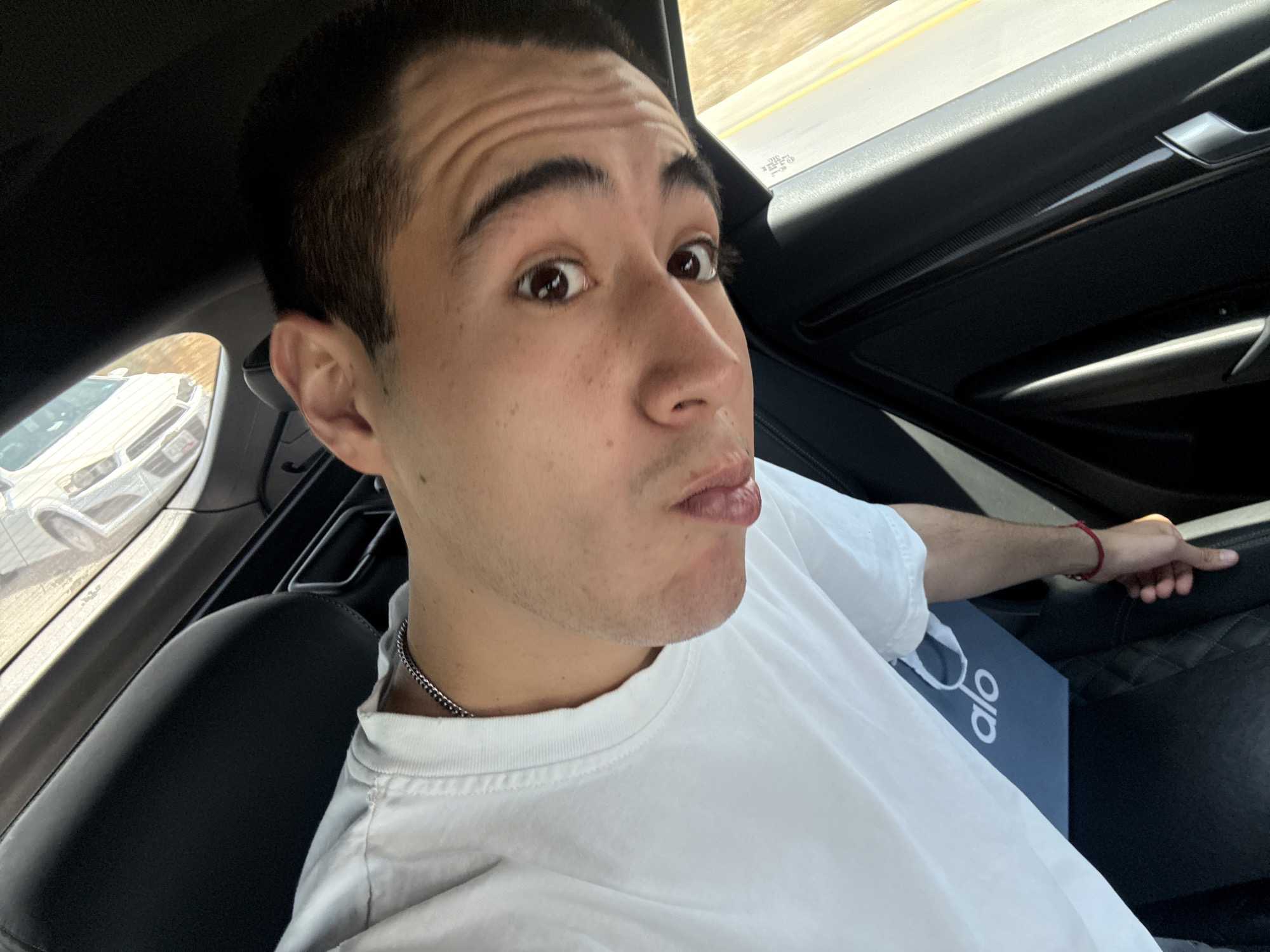 Young man takes selfie in car passenger seat