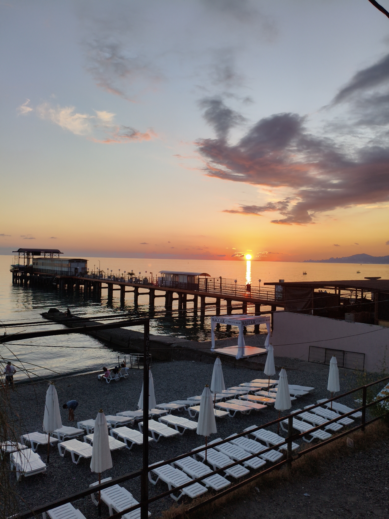 Sunset documented along Sochi's Black Sea coastline from railway platform