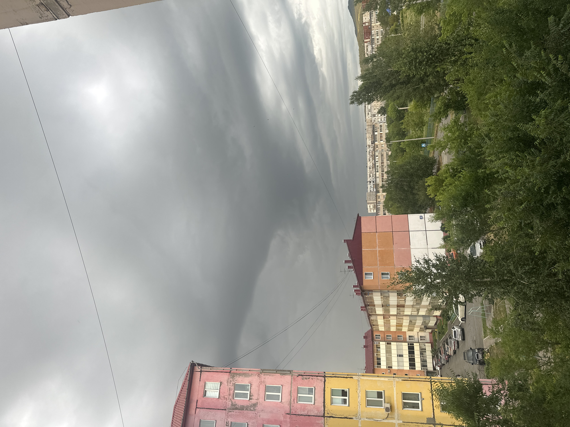 Storm clouds over Sayanogorsk apartments, with a gold-chained dog inside
