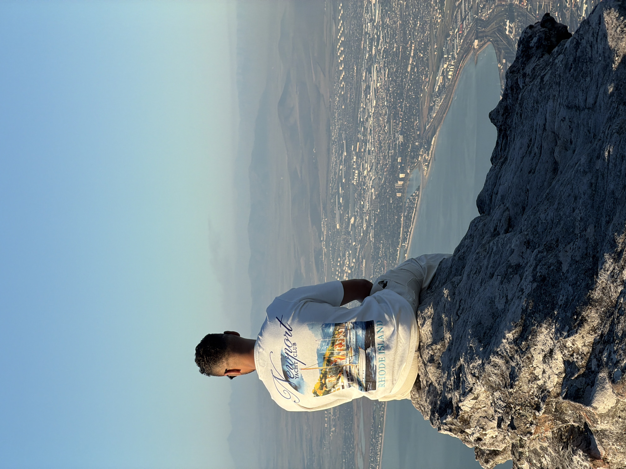 Cape Town mountain viewpoint draws contemplative visitors, paraglider overhead
