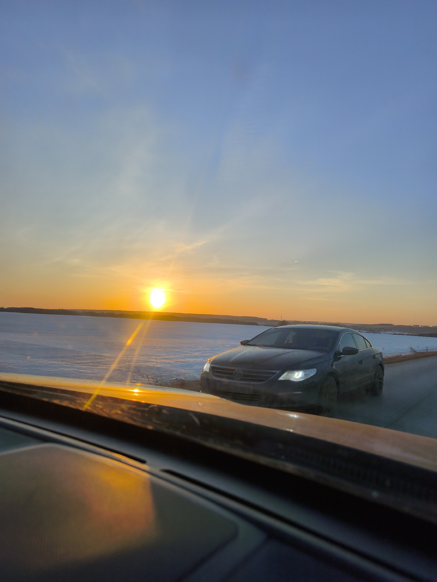Vehicle travels through snowy Russian countryside at sunset