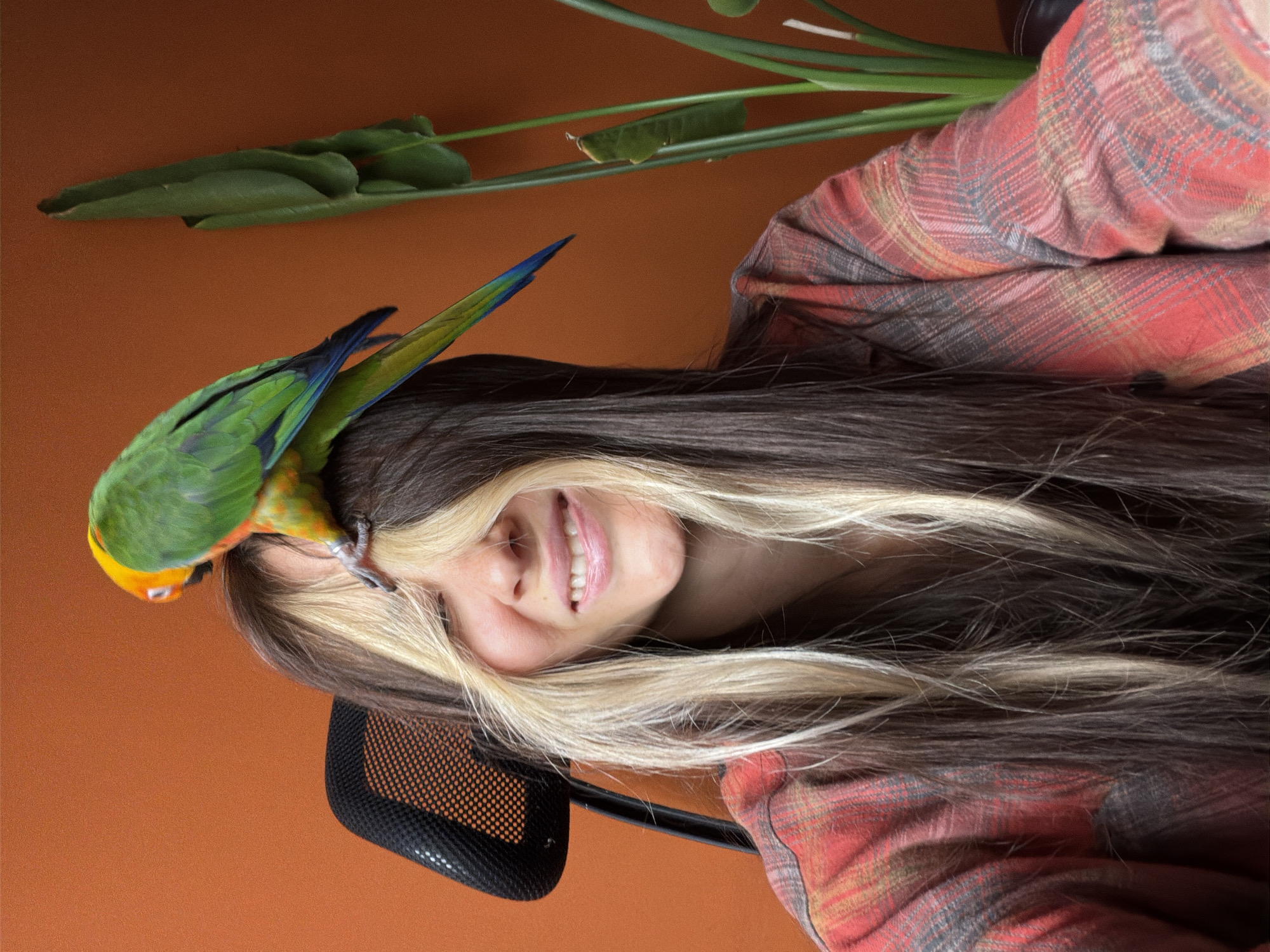 Woman poses with colorful parrot in Khimki home