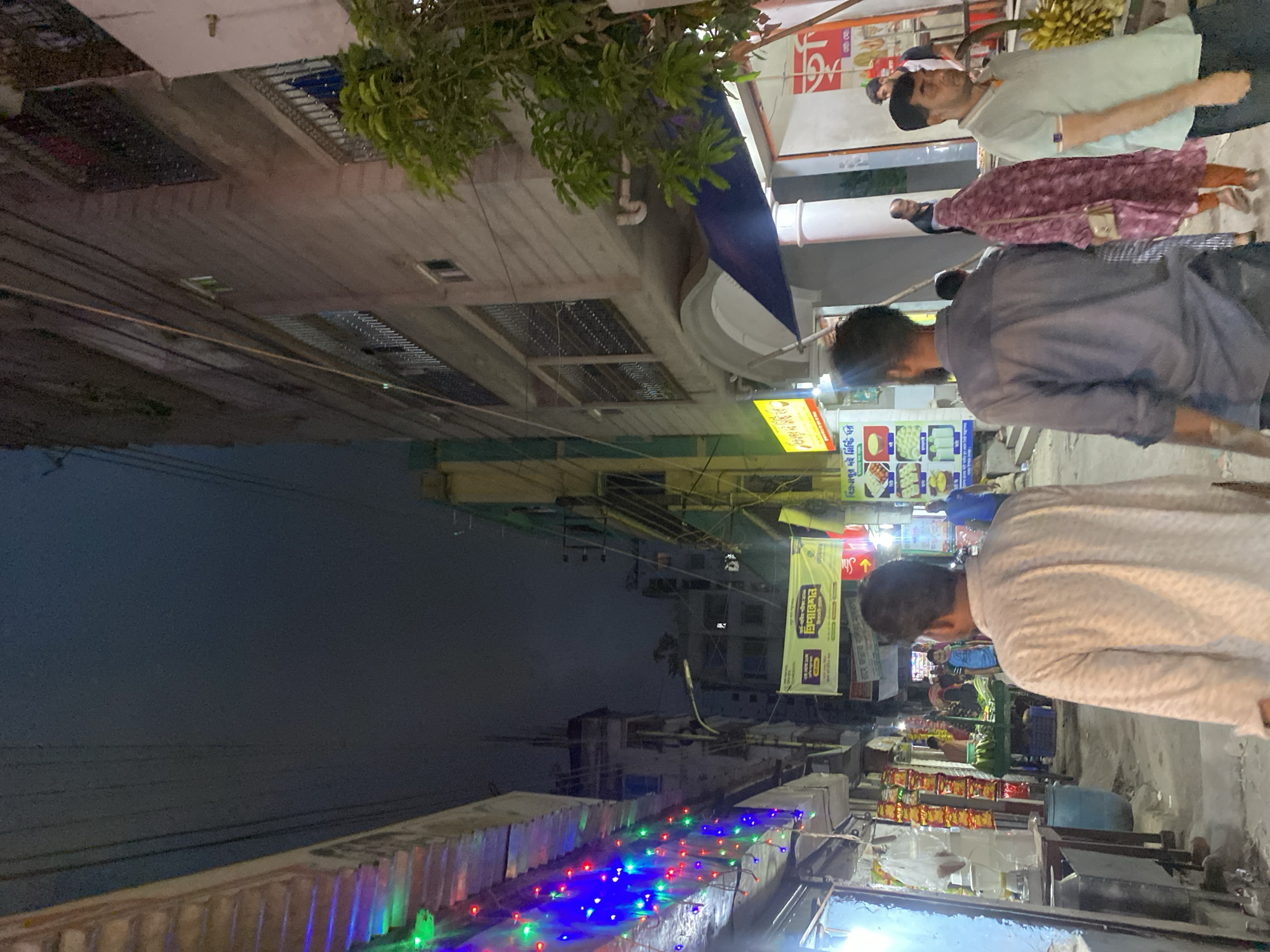 Evening street scene with colorful lights observed in Dhaka