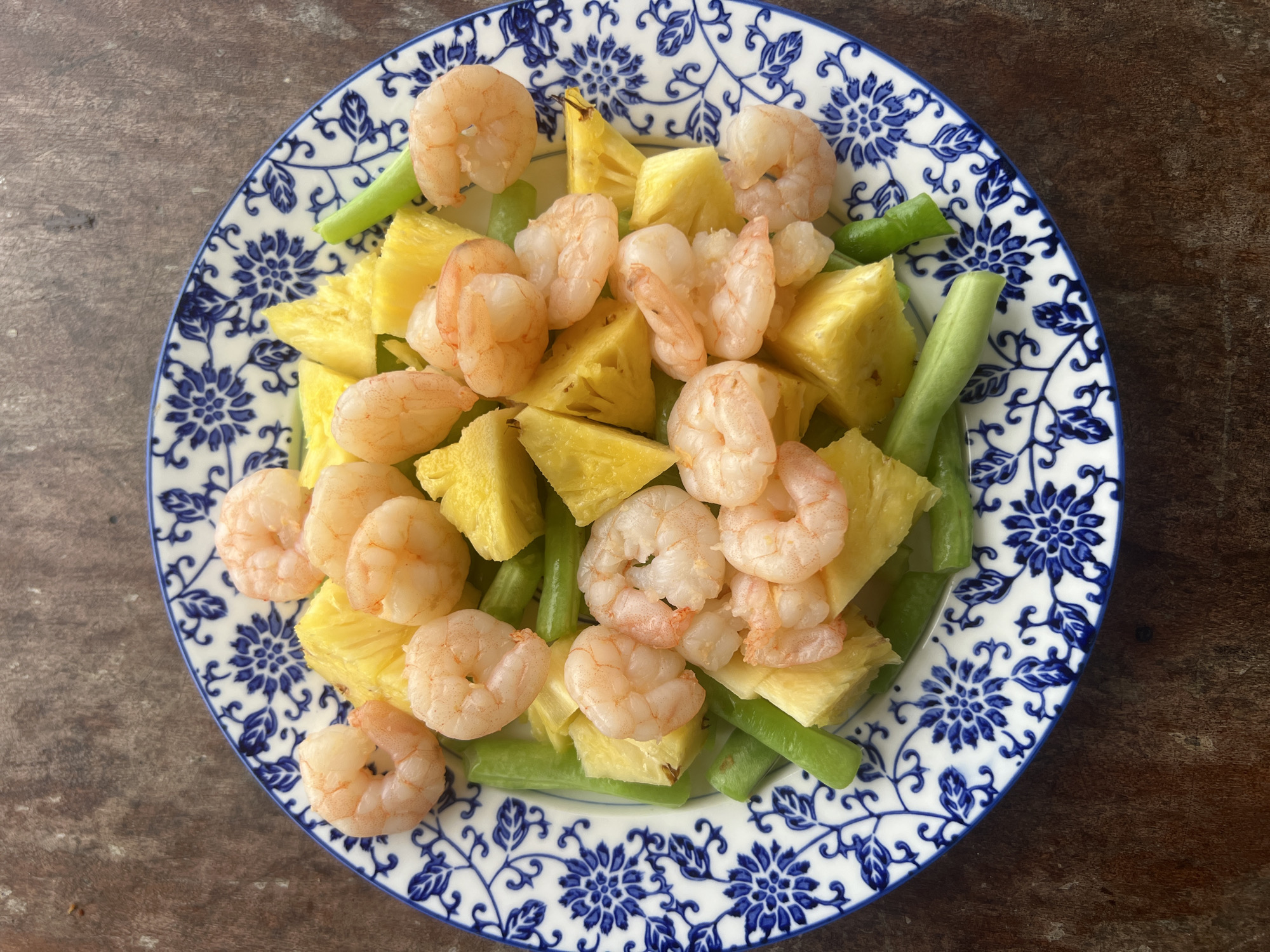 Shrimp and pineapple dish on a patterned plate in Hoi An