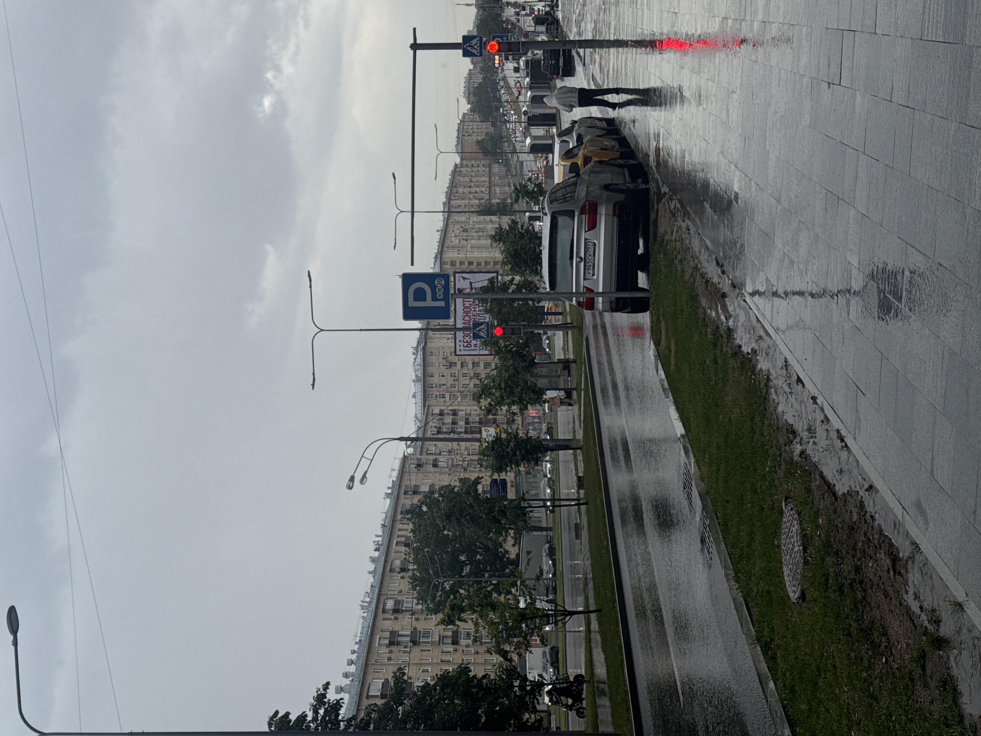 Rainy street scene with parked vehicles and umbrella perspective