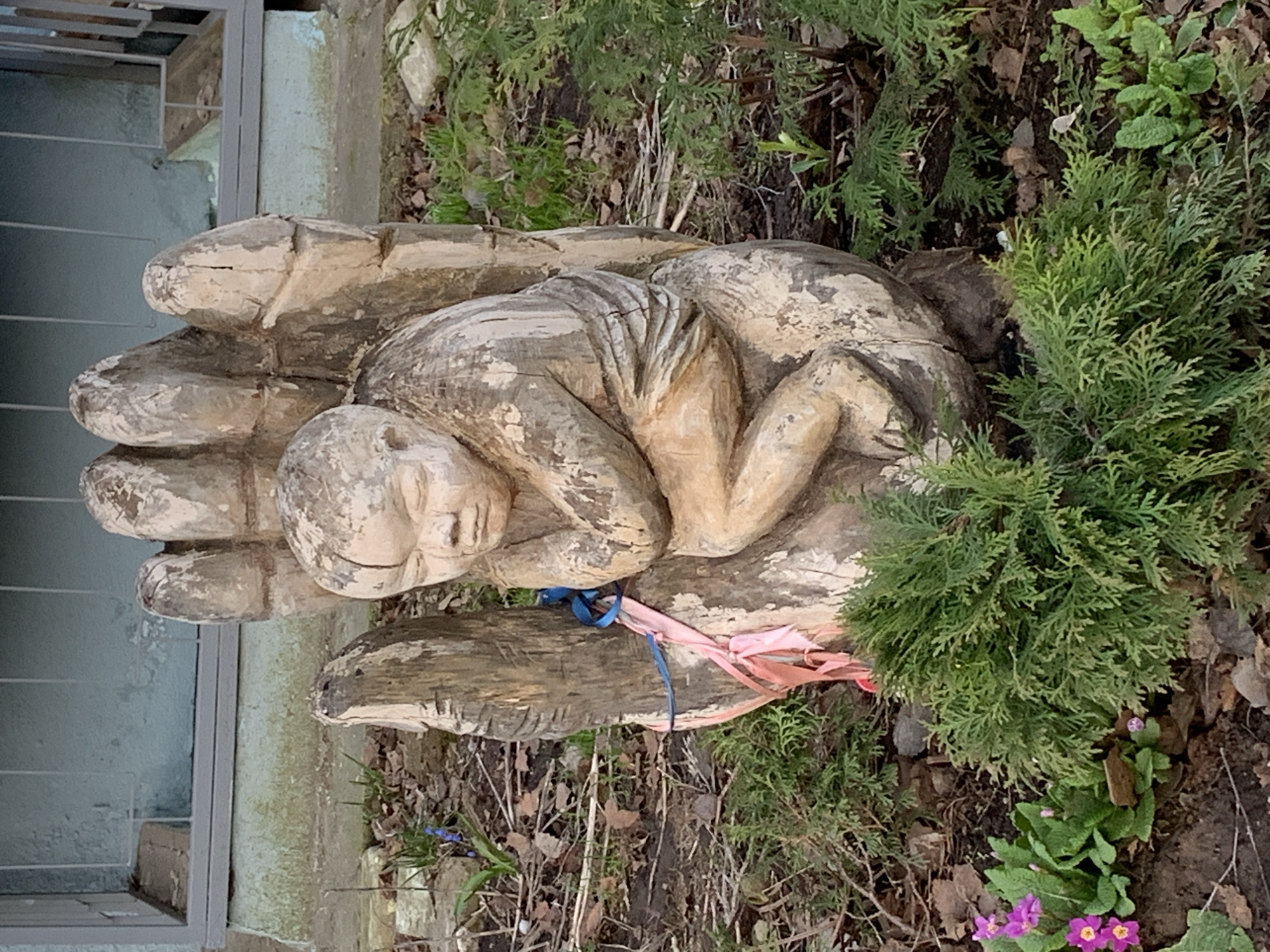 Woman photographs self near wooden sculpture in Chaikovsky, Russia