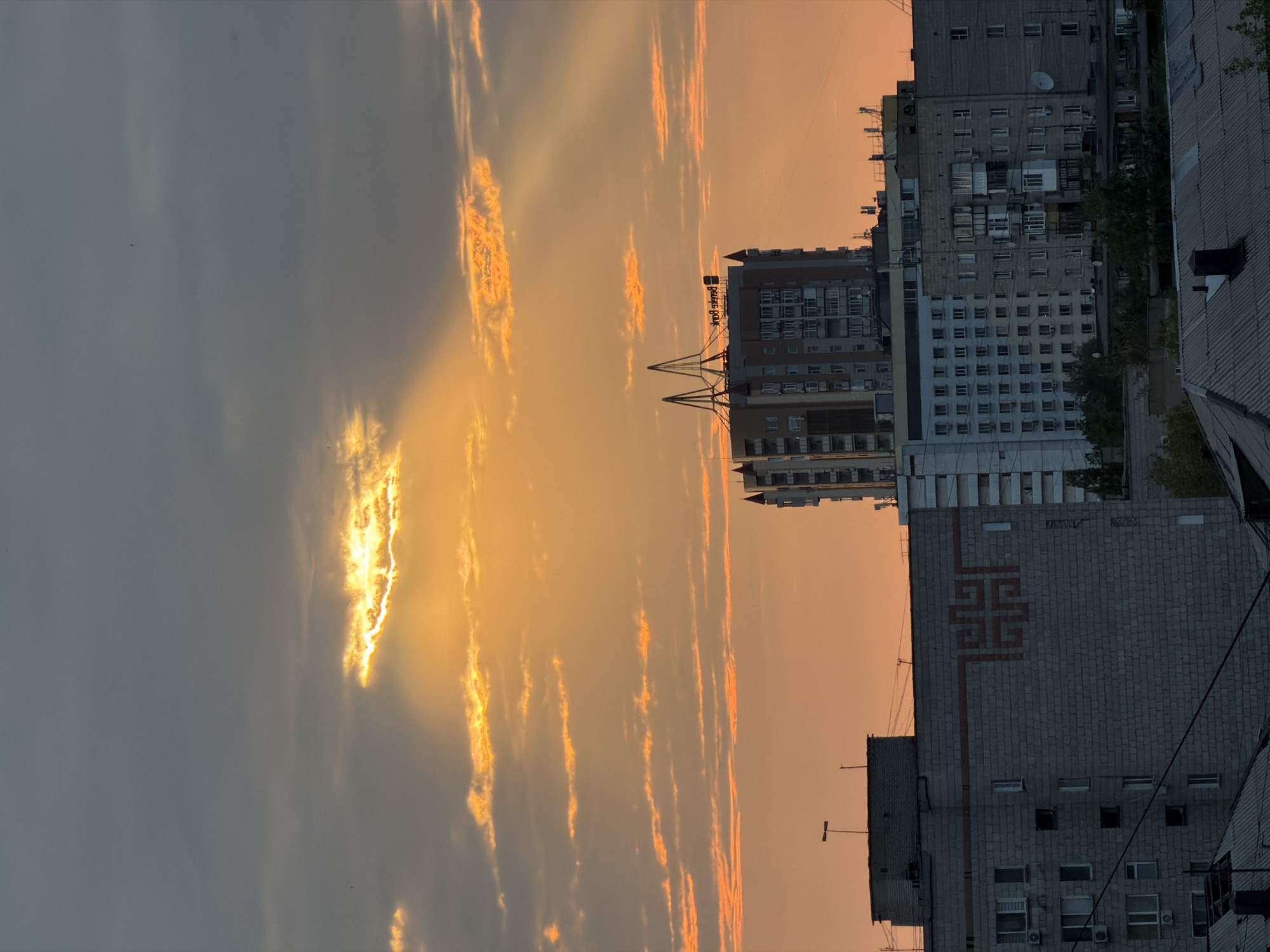 Golden light breaks through storm clouds over Pavlodar at sunset