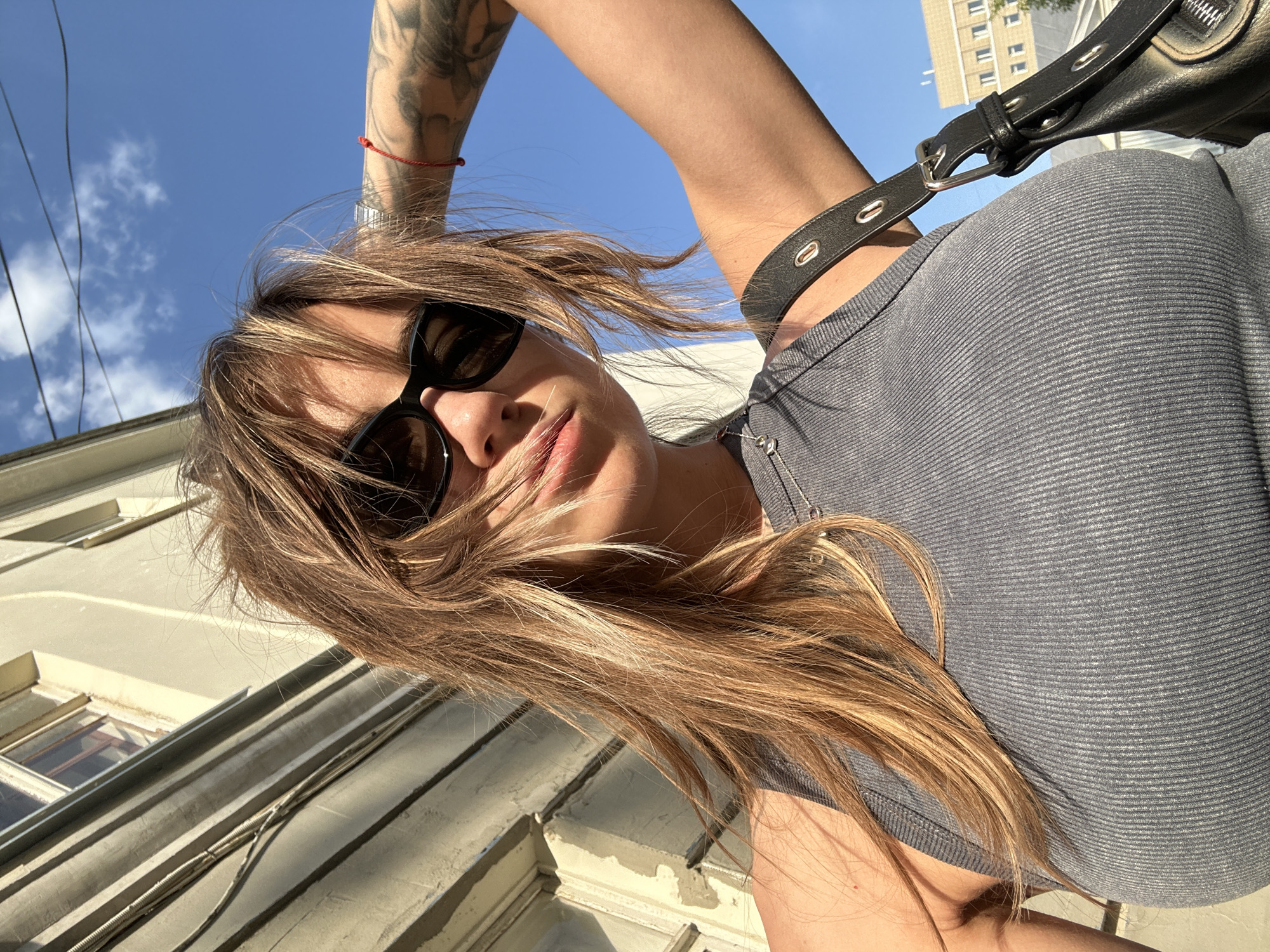 Woman takes selfie in Moscow wearing sunglasses and tank top