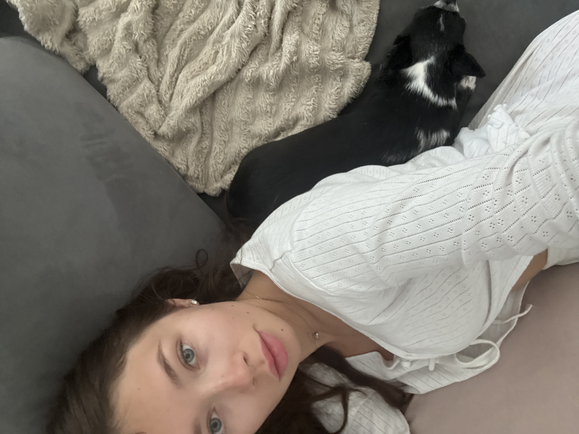 Woman and dog rest together on sofa in Ramat Gan