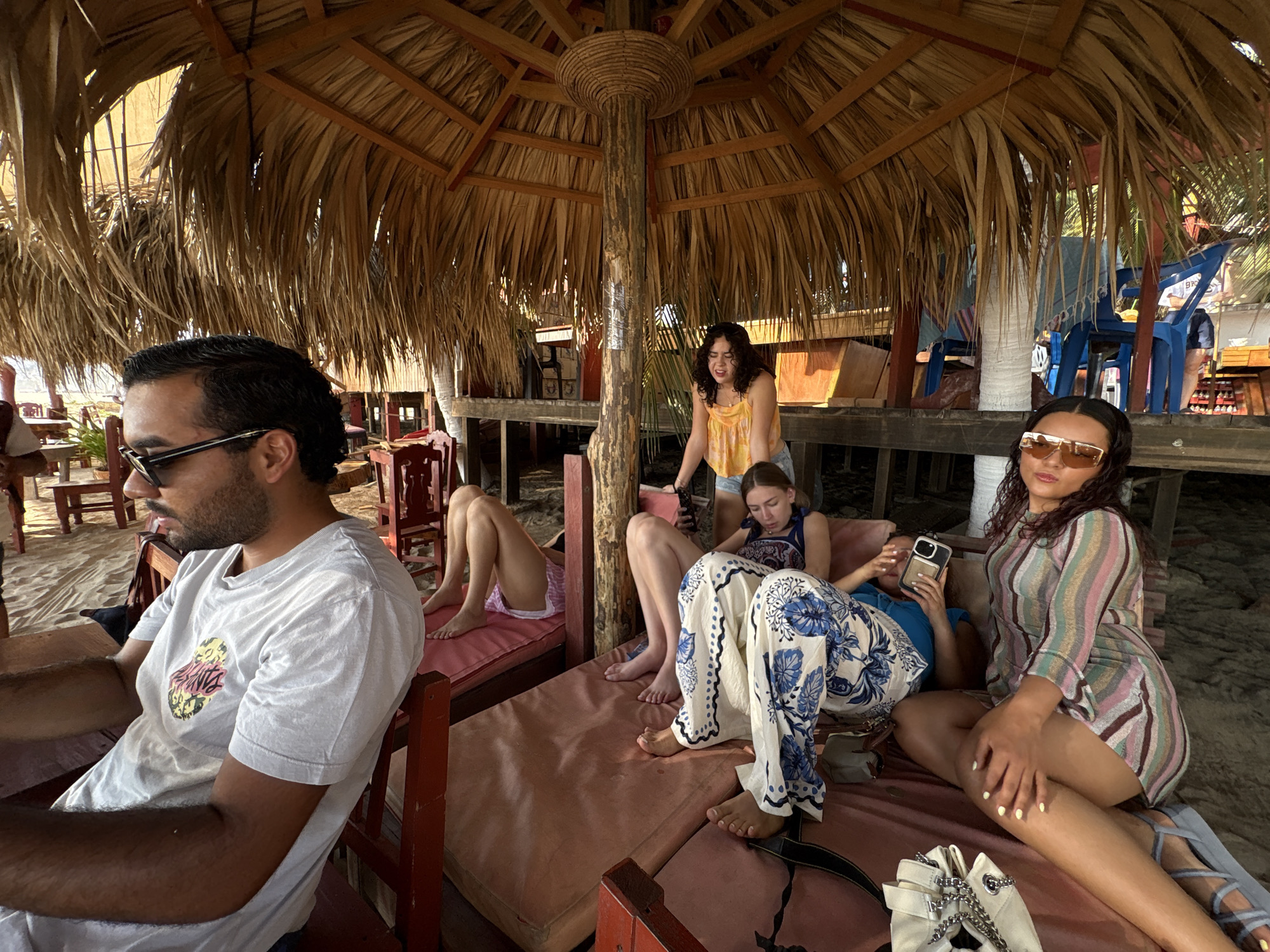 Friends gather at beach palapa in Brisas de Zicatela