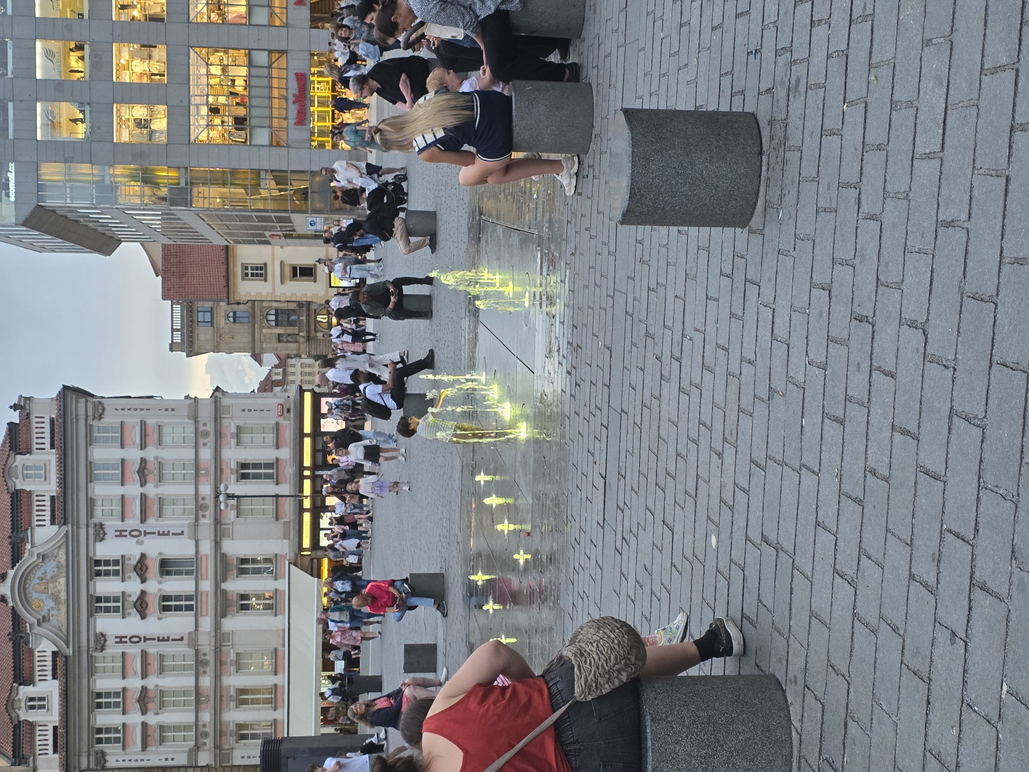 Evening urban life documented around Franz Kafka sculpture location