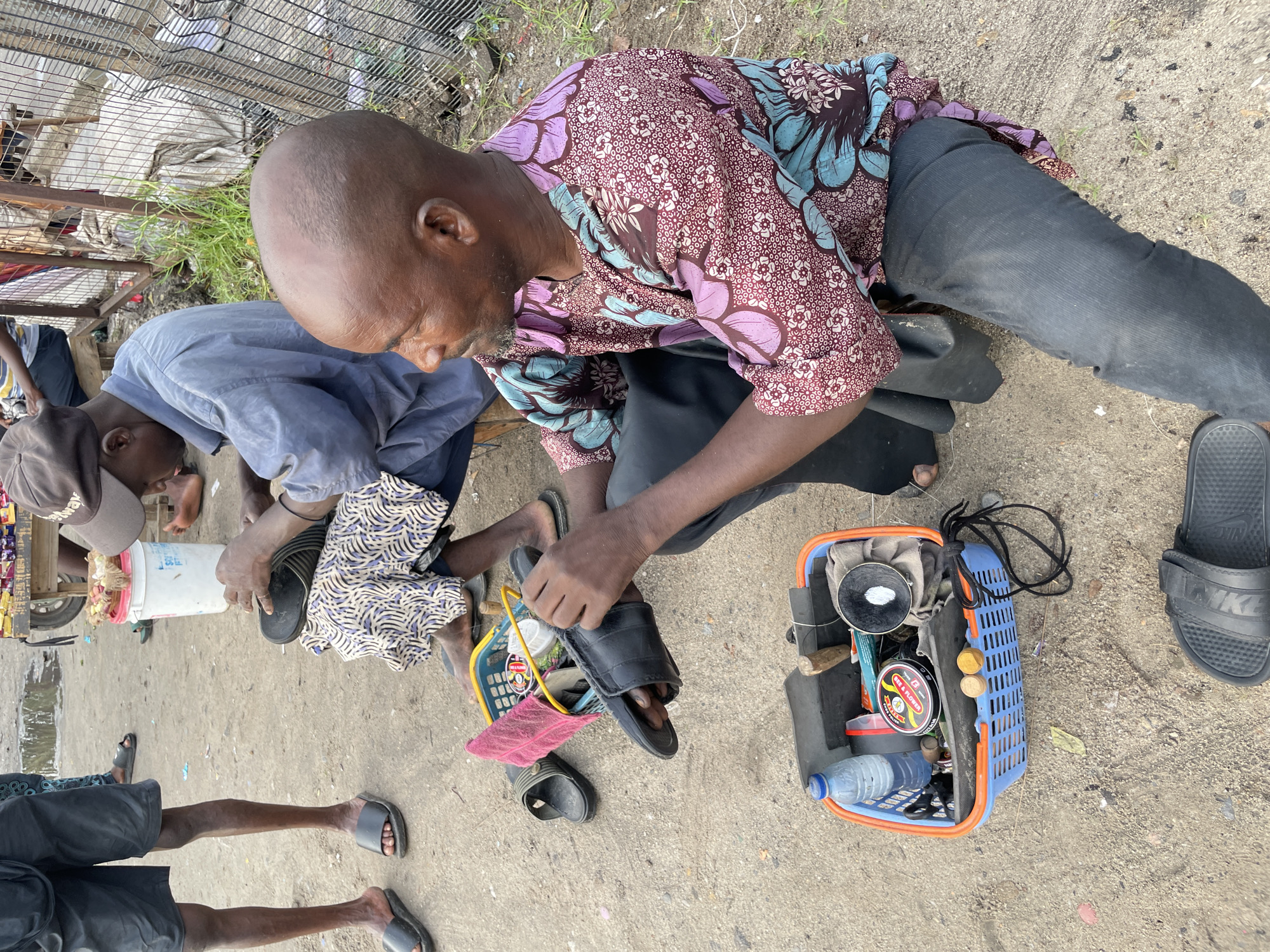 Morning street commerce and shoe repair in Ilado Nigeria