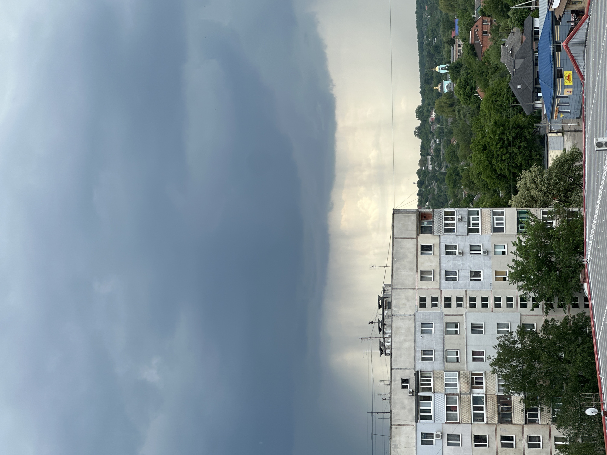 Dramatic storm clouds contrast with clear sky over urban area