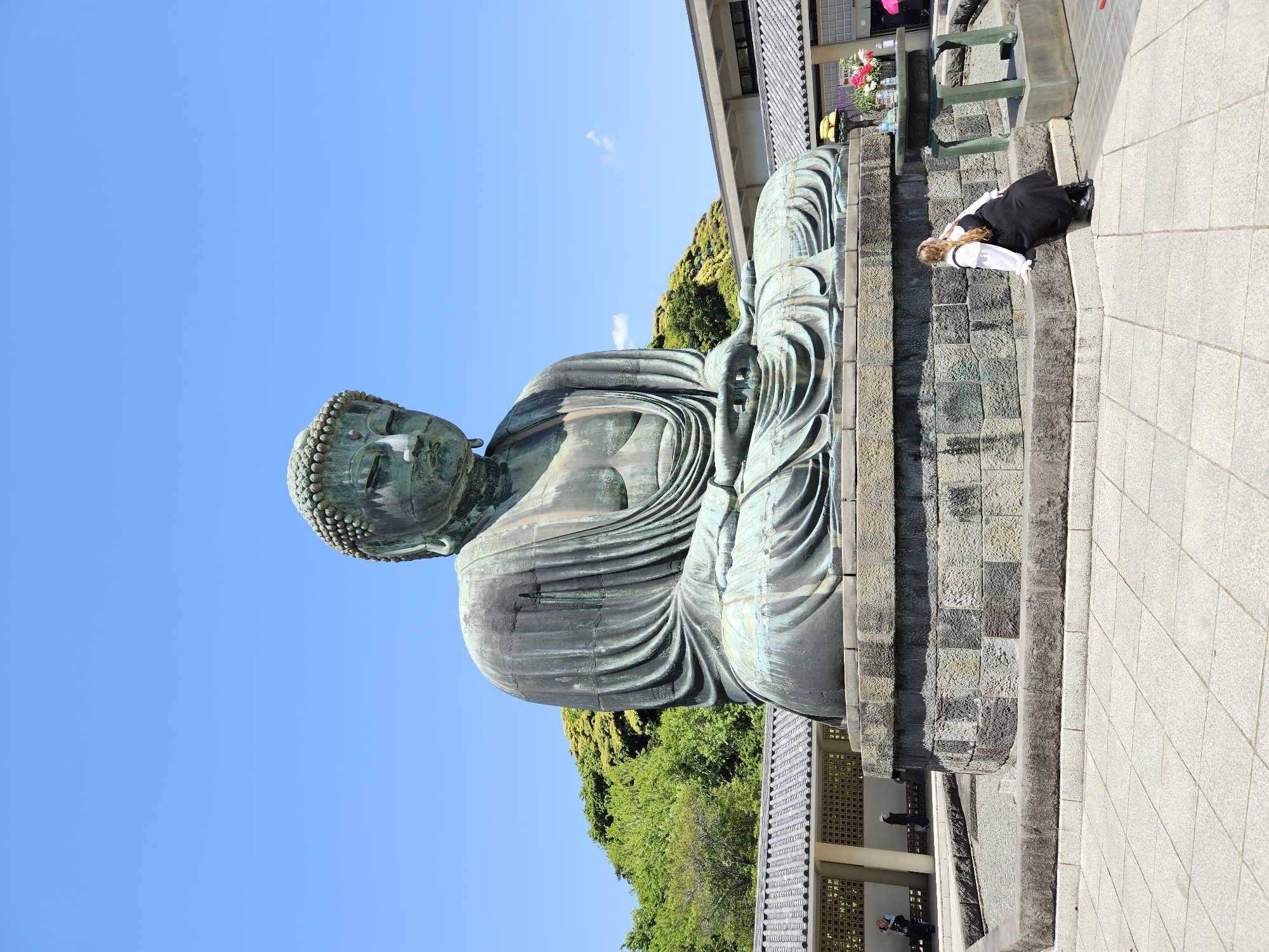 Visitor photographs iconic Great Buddha statue in Kamakura