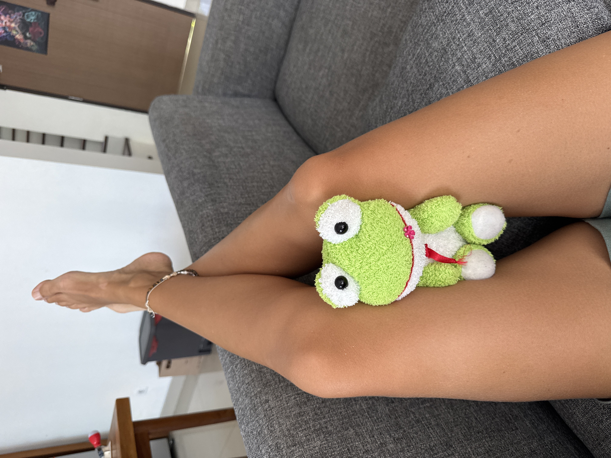 Person relaxes with plush frog toy in Kuta Selatan