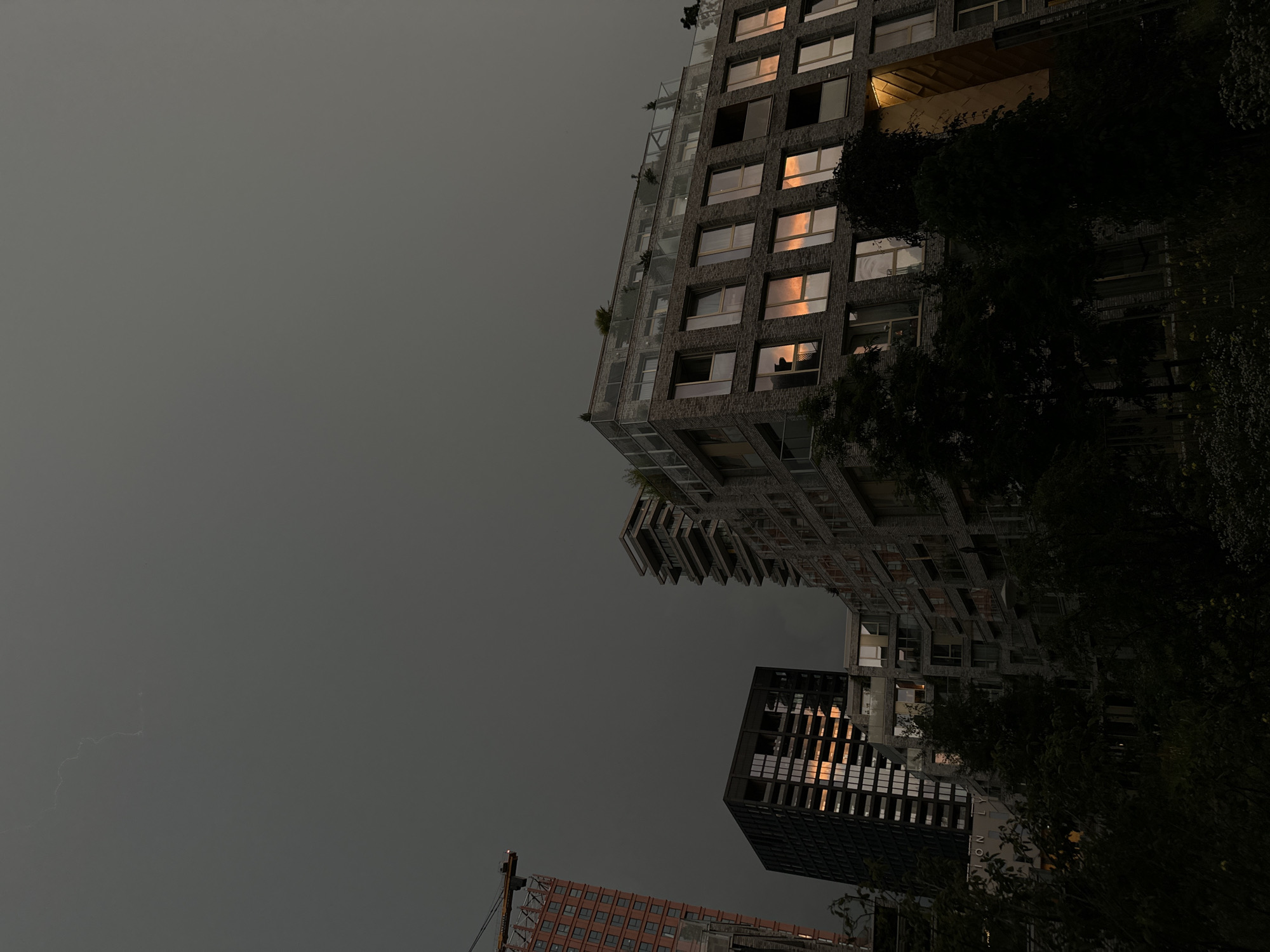 Amsterdam skyline under a stormy evening sky, crane and all
