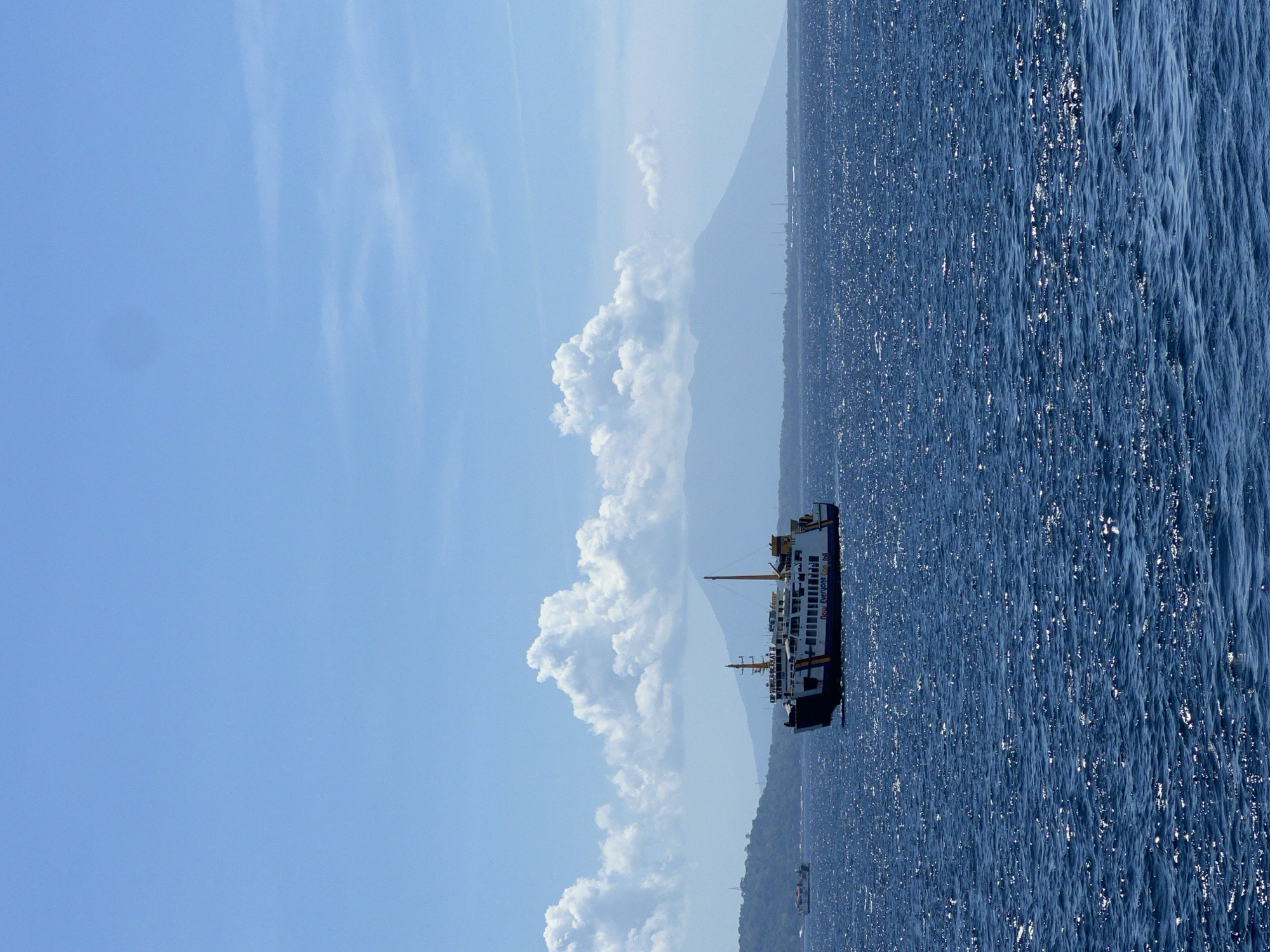 Ferry passengers document morning journey off Melaya, Indonesia coast