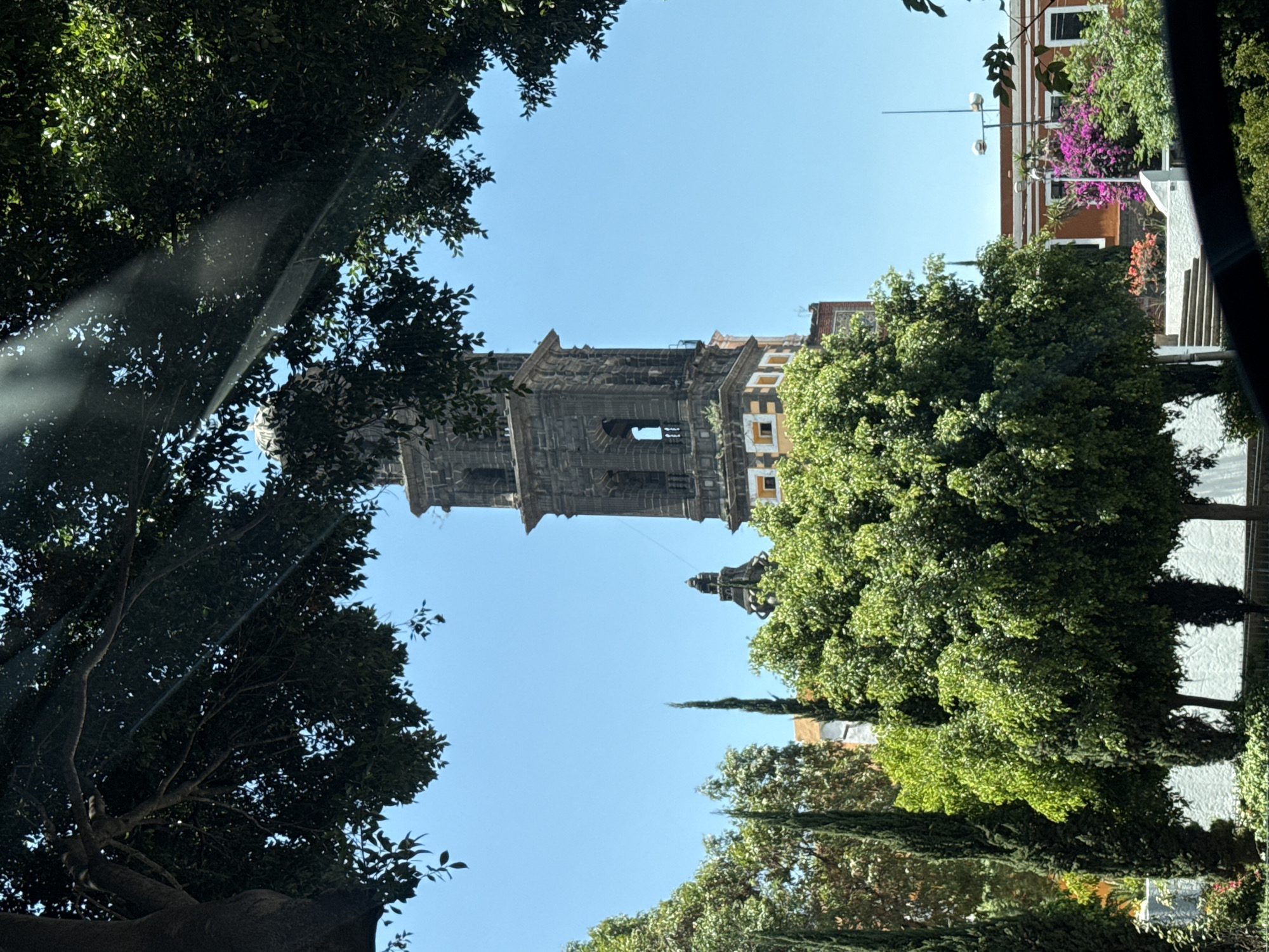 Tourist documents bell tower and car selfie in Puebla