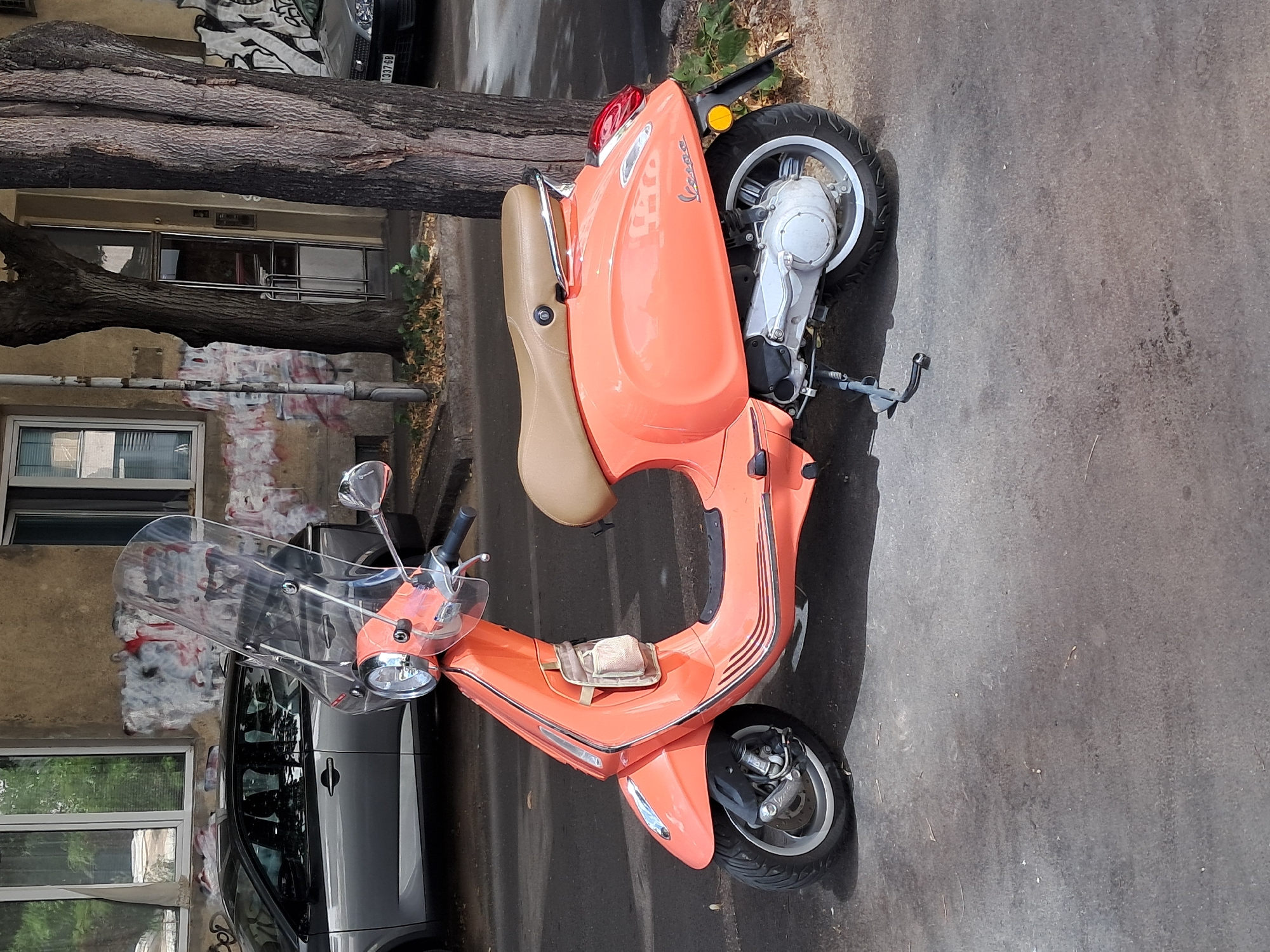 Orange Vespa parked outside a weathered Belgrade building