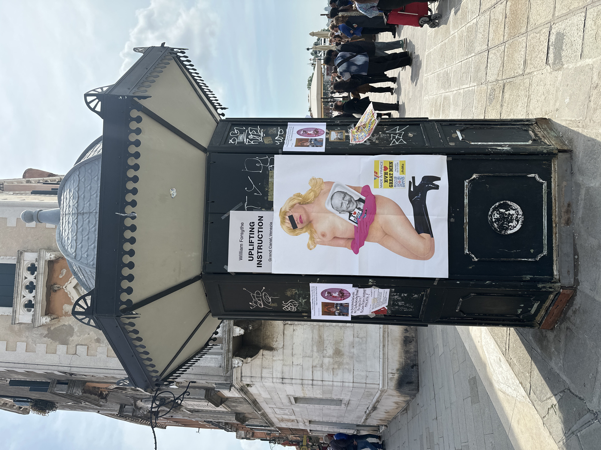 Vandalized ornate kiosk documented in Venice with graffiti, posters