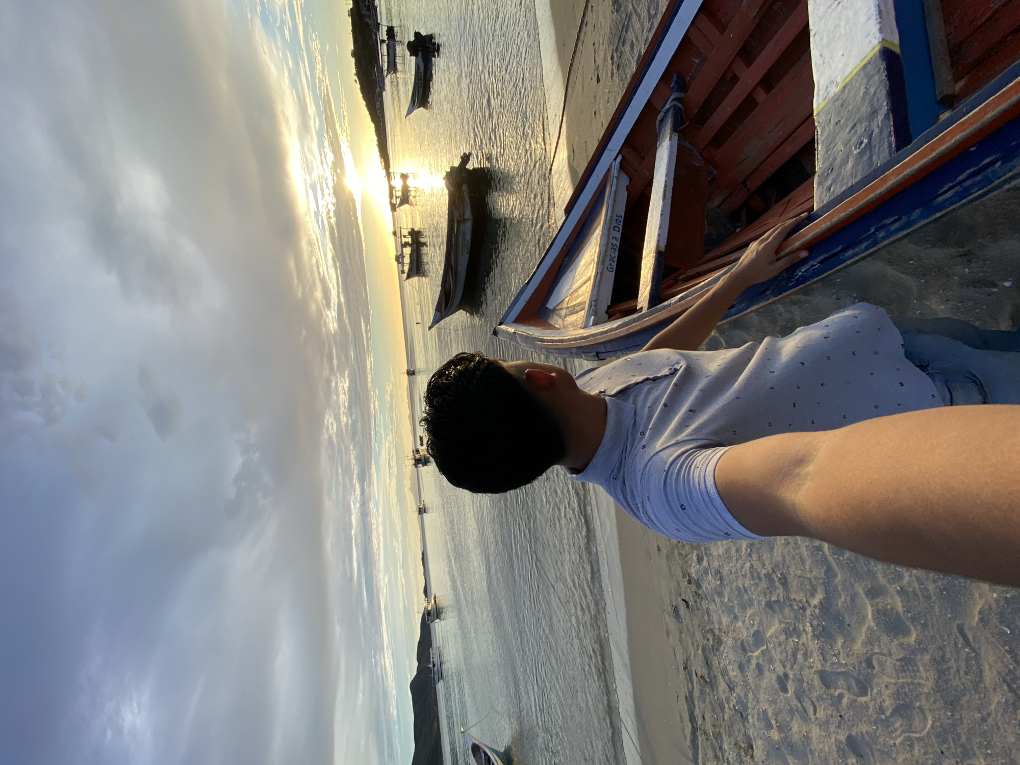 Sunset over Juan Griego Bay, boats and palms at dusk