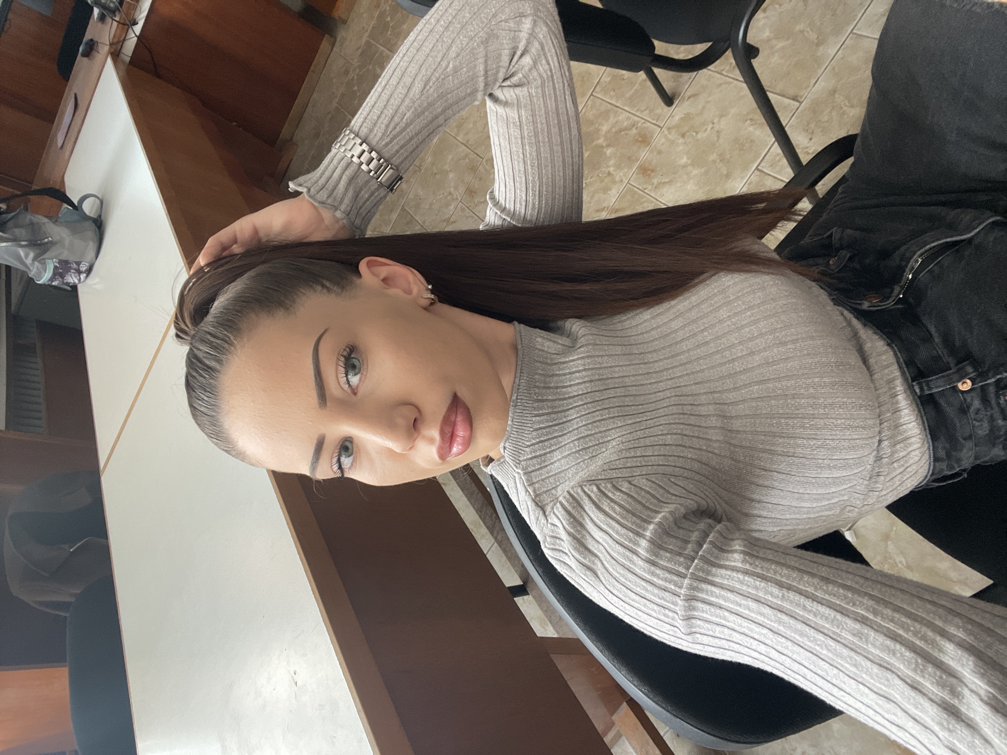 Woman sits in chair touching hair in Veliko Tarnovo