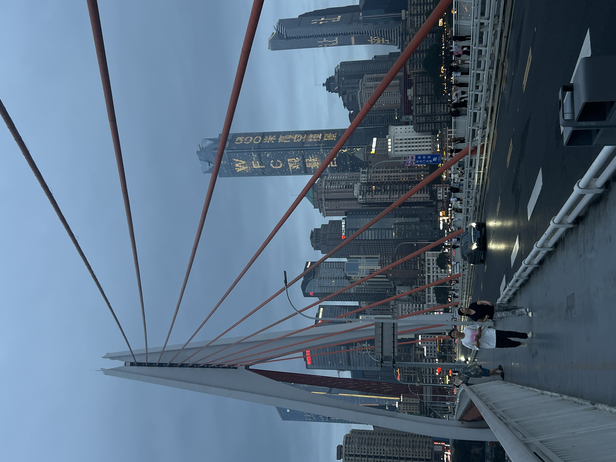 Orange cables and city skyline from a Chongqing bridge