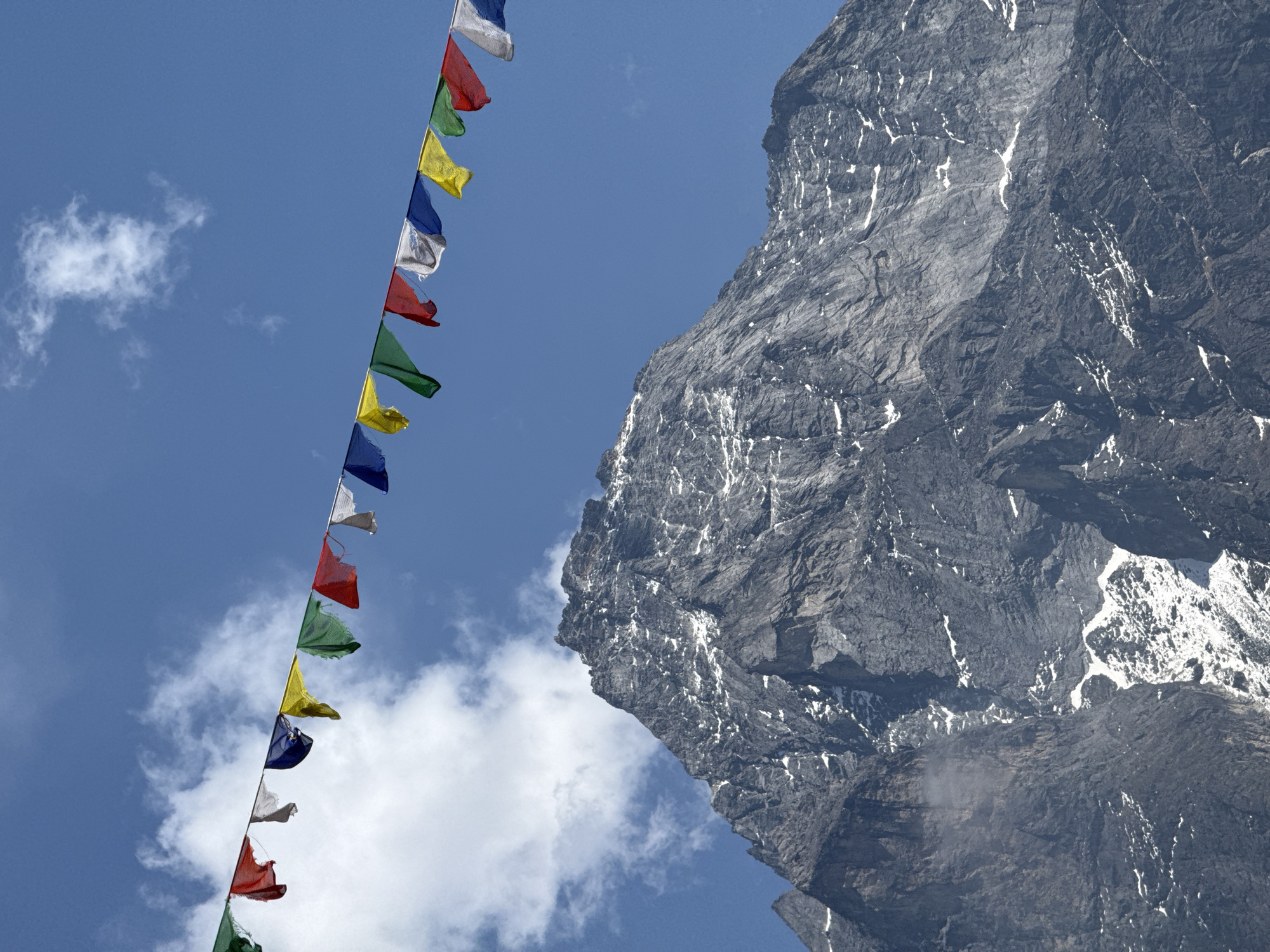 Prayer flags photographed against mountain backdrop in Khumjung, Nepal