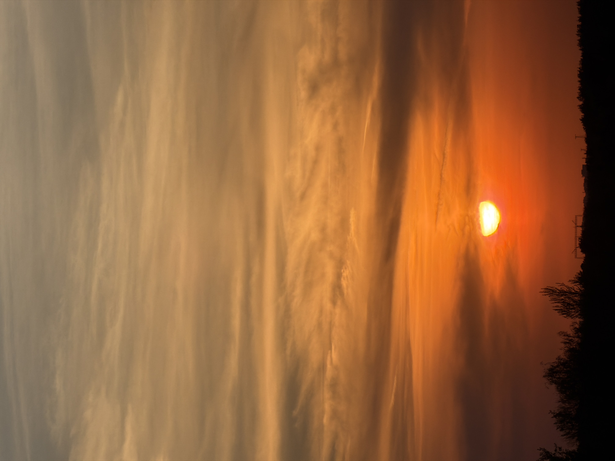 Sunset observed with orange hues and cloud cover
