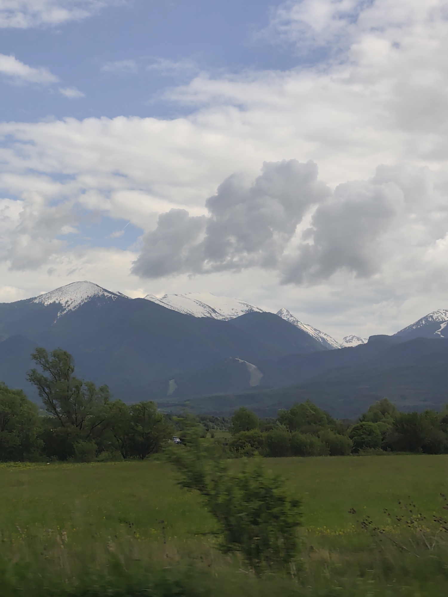 Snow-capped Pirin Mountains viewed from Razlog field under overcast skies