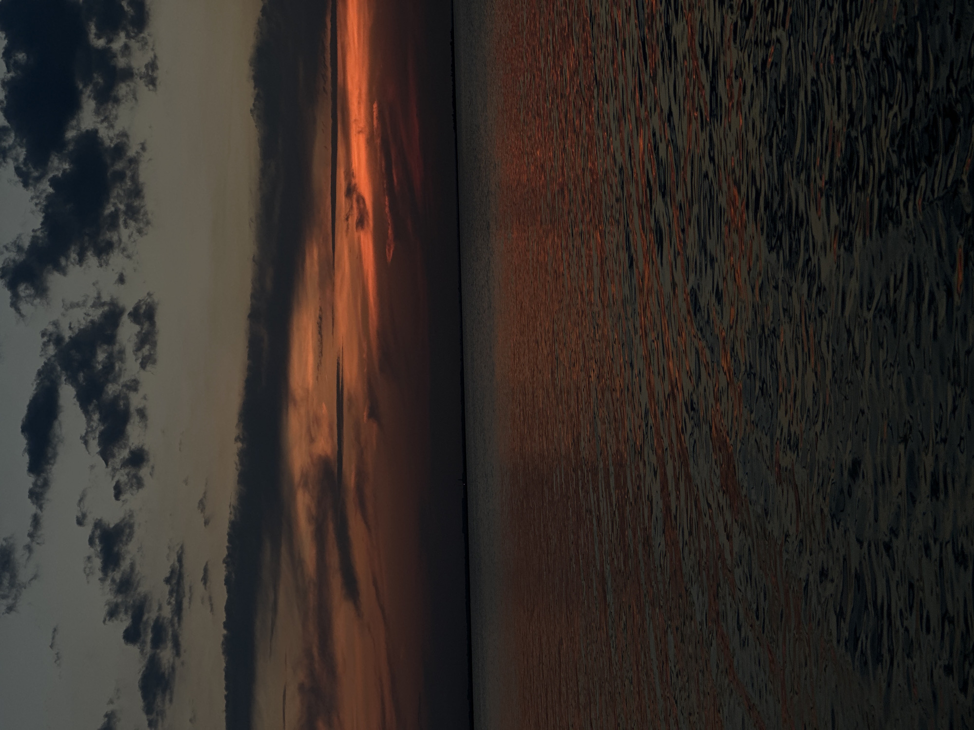 Sunset on a Kokshetau lake, boats and people on the water's edge